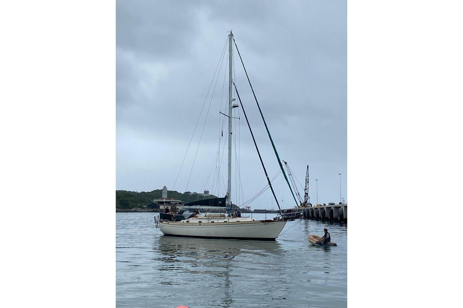1987 Ta Shing Baba 40 sailboat docked near a pier under cloudy skies.