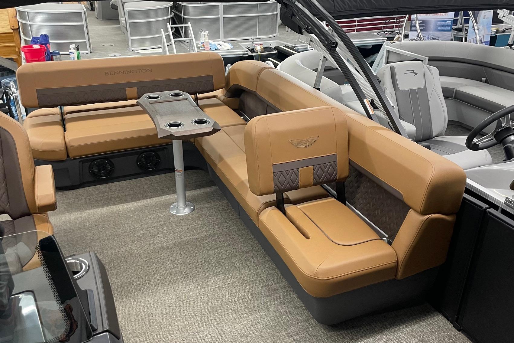 2025 Bennington 22 M CRUISE boat interior with tan seating and cupholder table.