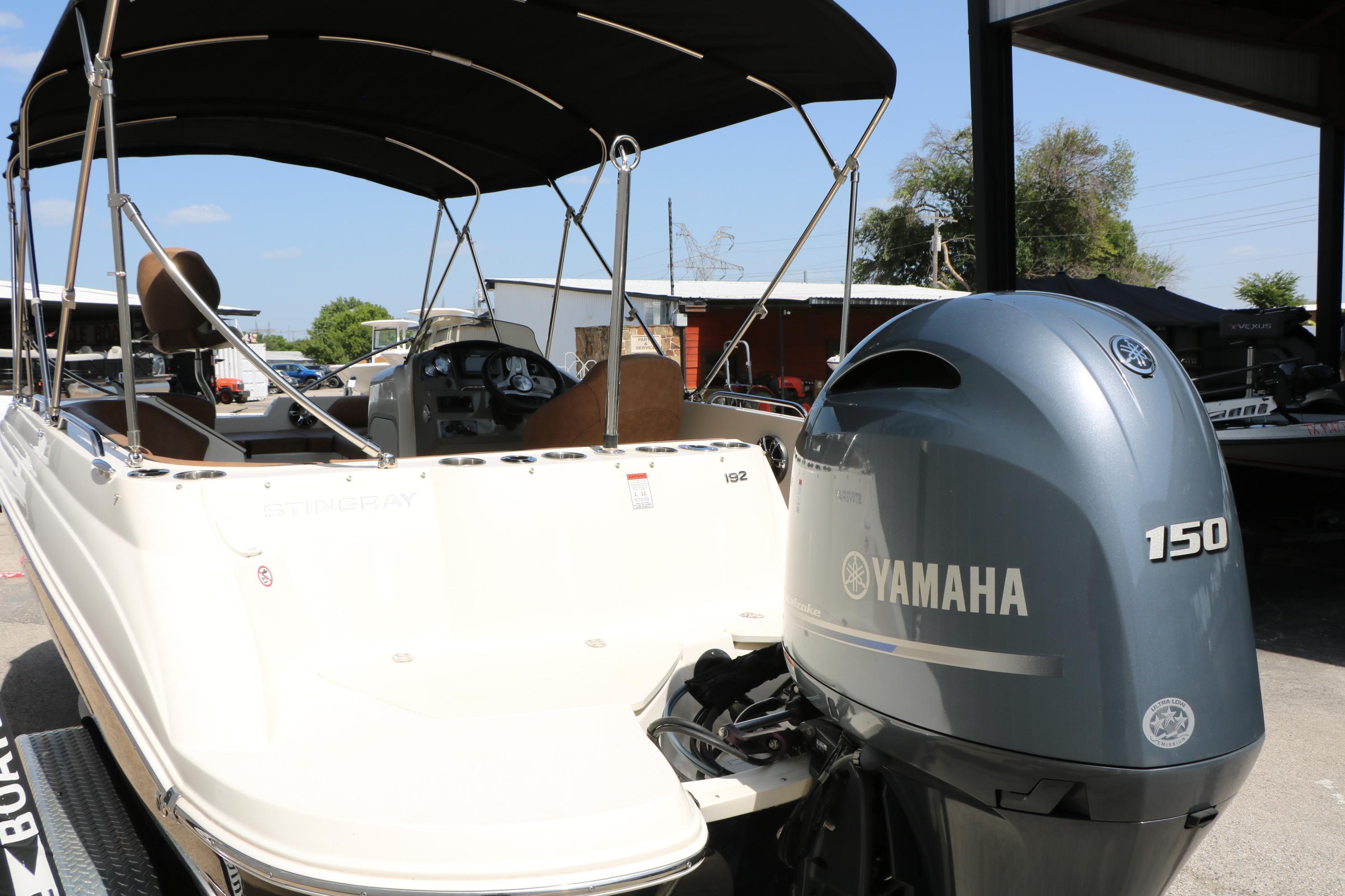 2022 Stingray 192 SC boat with Yamaha 150 engine, parked outdoors under a canopy.