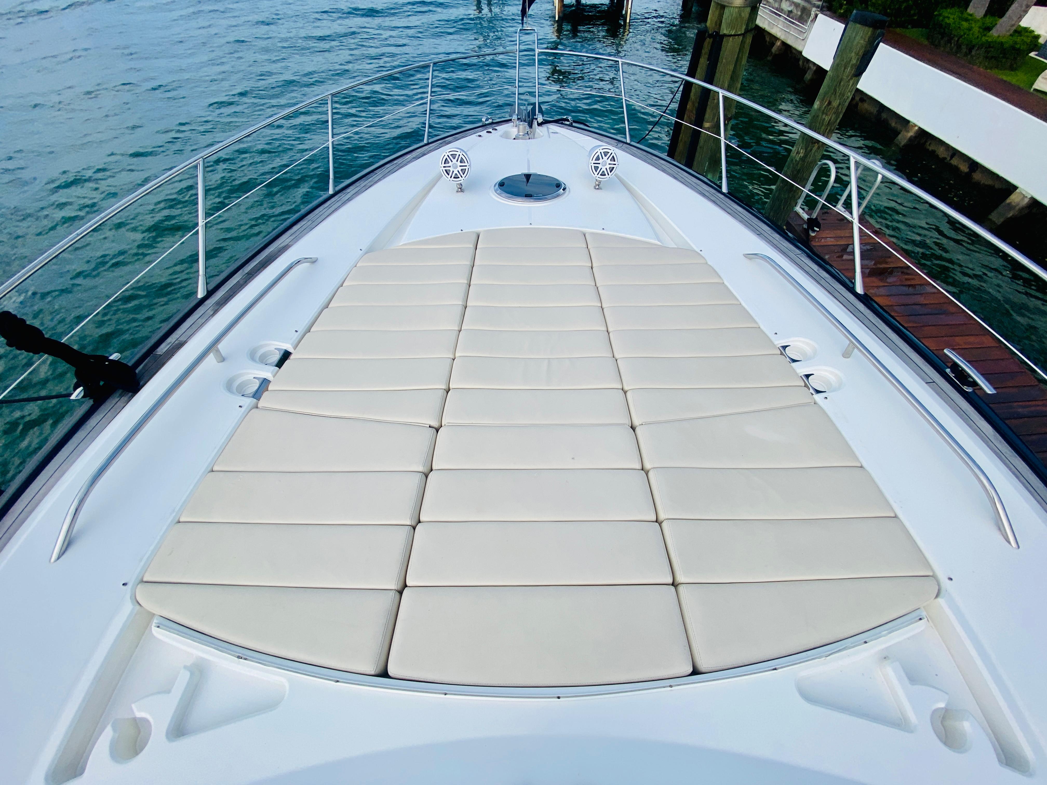 Sunseeker Predator 60 2010 yacht bow with sunpad, docked by the water.