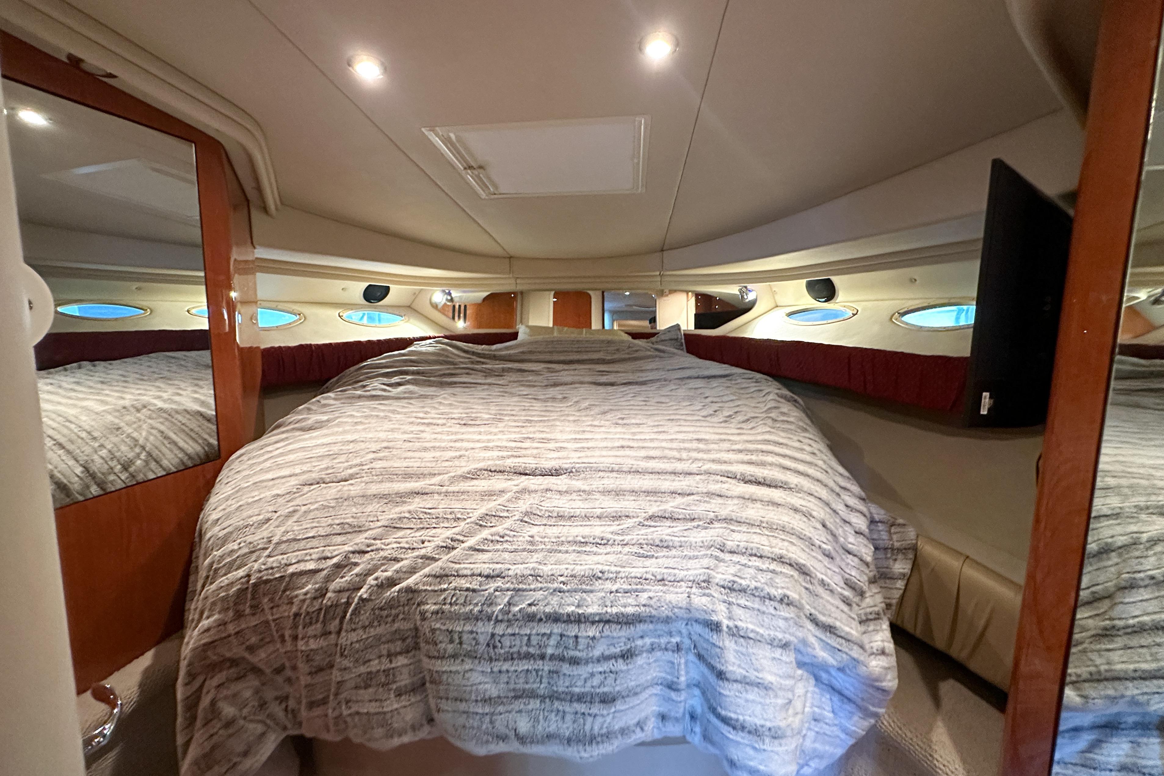 Luxurious cabin interior of 2001 Sea Ray 410 Sundancer yacht with cozy bedding.