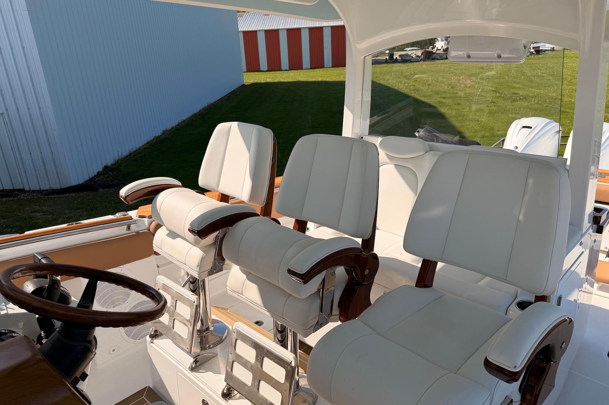Luxury seating on 2022 HCB 42 Lujo boat, featuring elegant white upholstery and wooden accents.