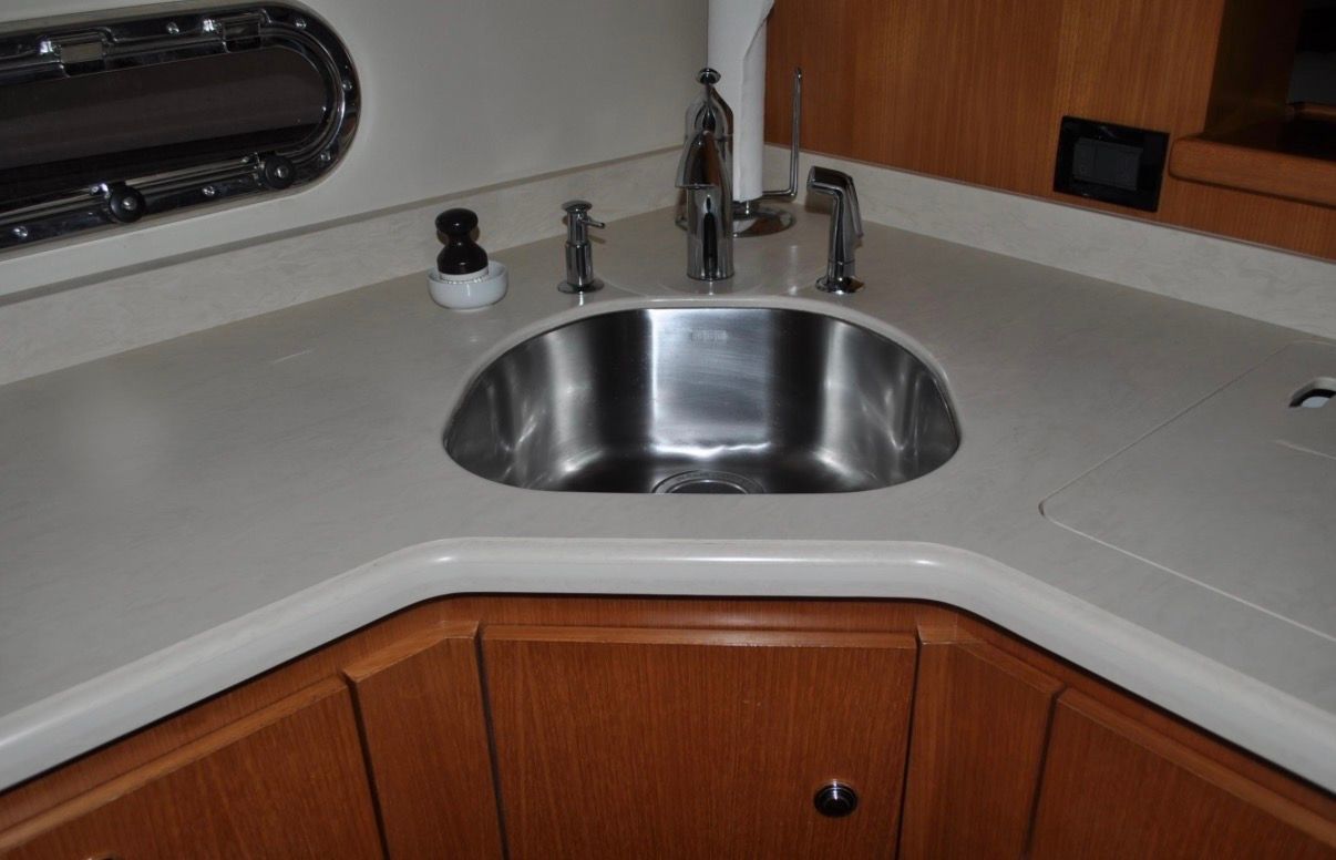 The 2005 Tiara Yachts 5200 Sovran's galley features a sink and wooden cabinetry.