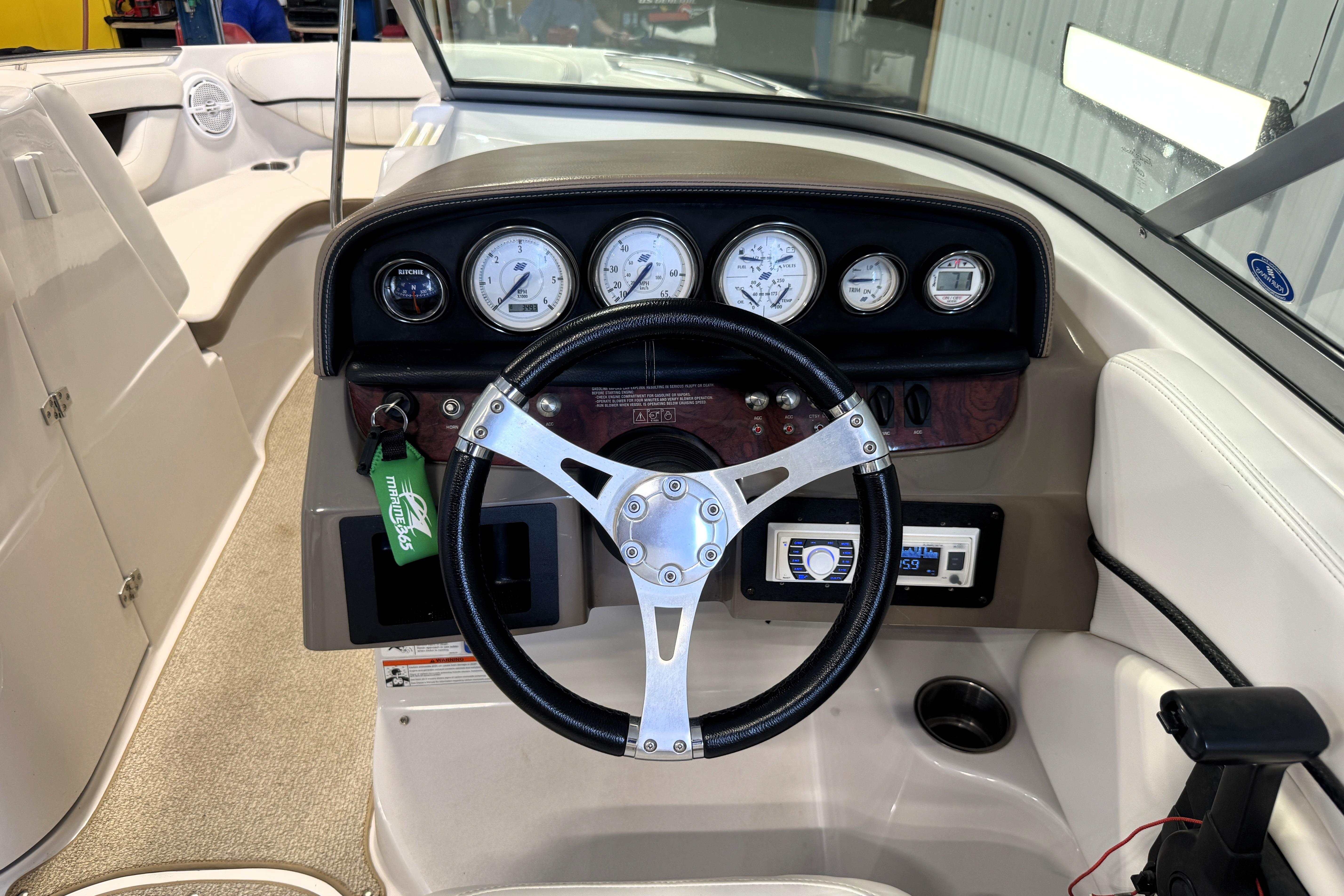 2008 Four Winns H240 boat dashboard with steering wheel and instrument panel.