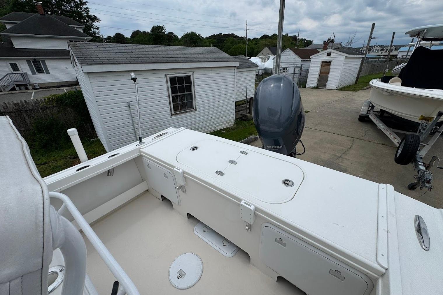 2014 Steiger Craft 21 Tournament boat with outboard motor, parked near white buildings.