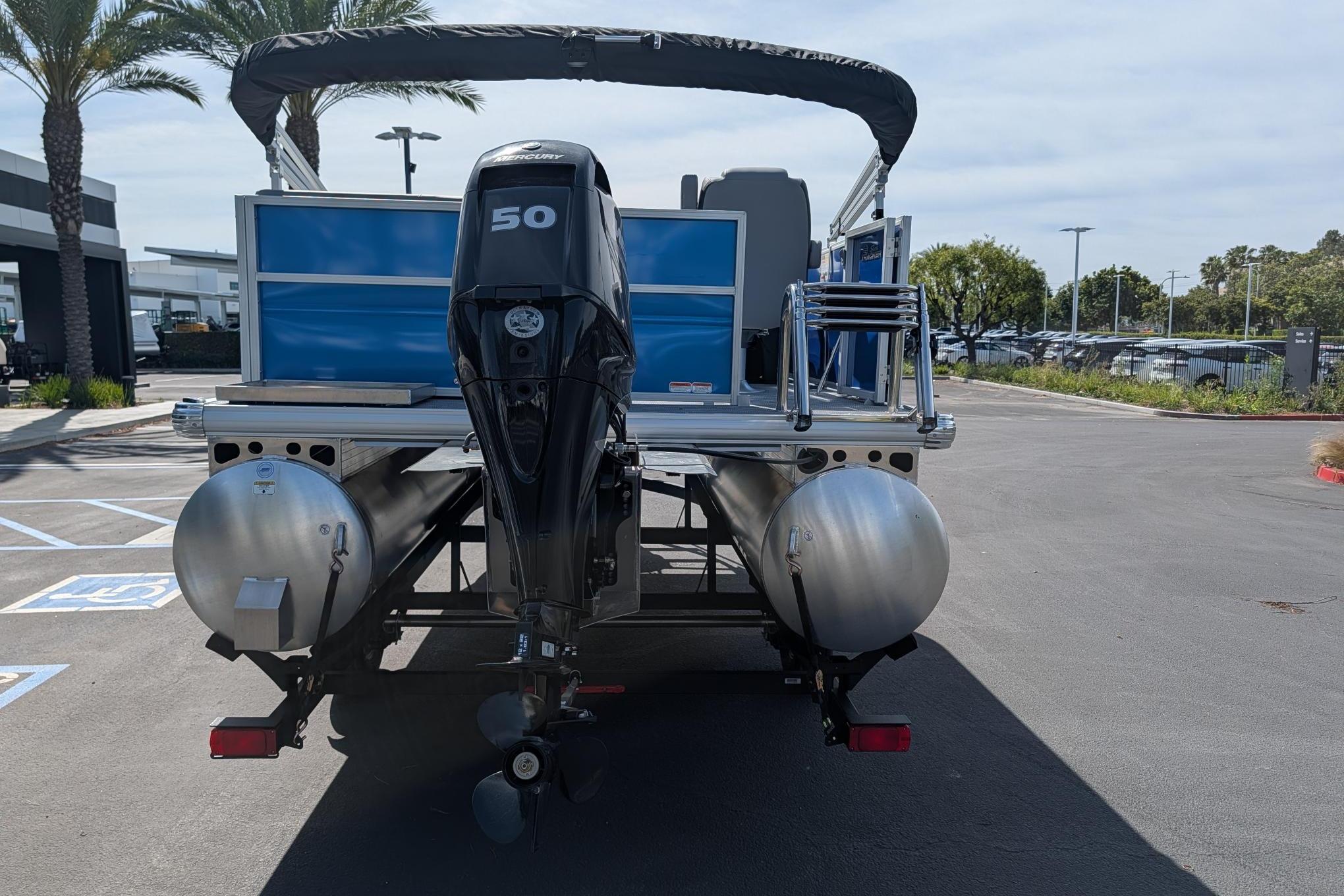 2026 Sun Tracker Party Barge 16 DLX pontoon boat with Mercury 50 engine, parked outdoors.