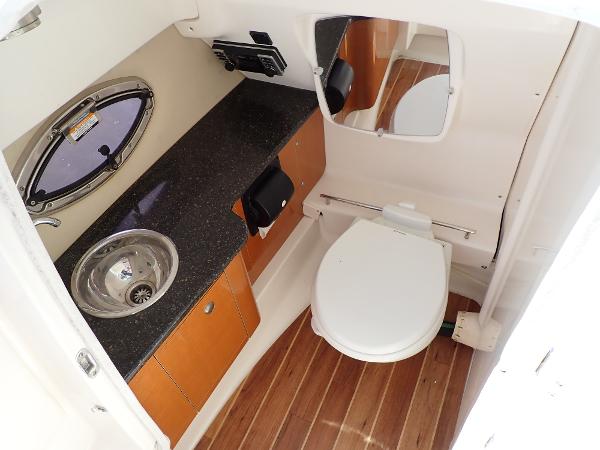 2011 Chaparral 287 SSX boat bathroom with sink, toilet, and wooden flooring.
