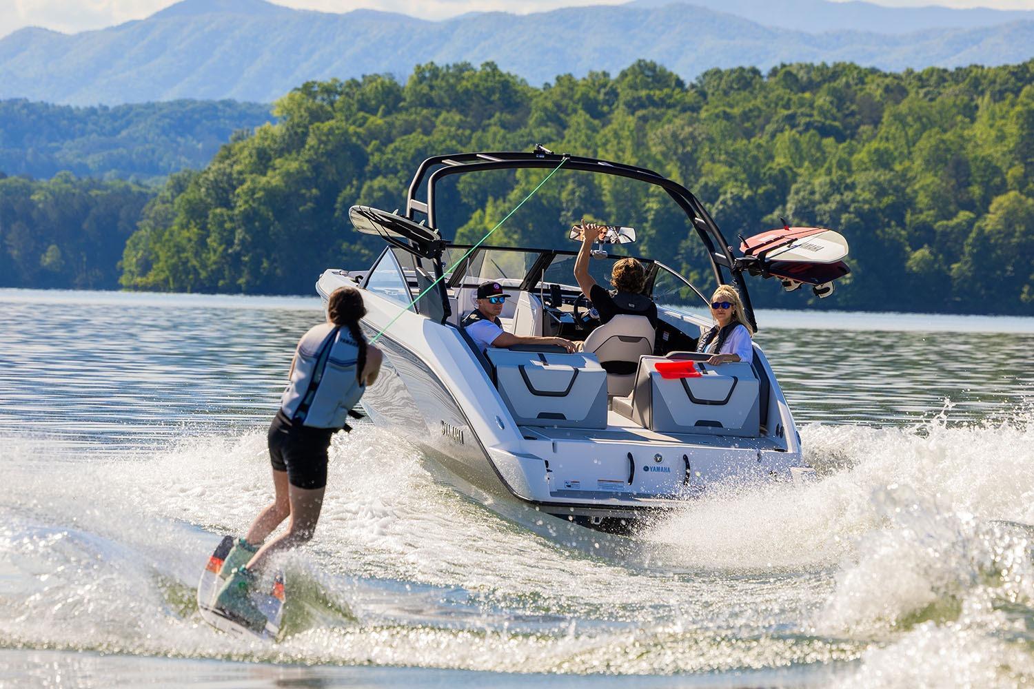 Manufacturer Provided Image: 2026 Yamaha Boats AR220 towing a wakeboarder on a scenic lake.