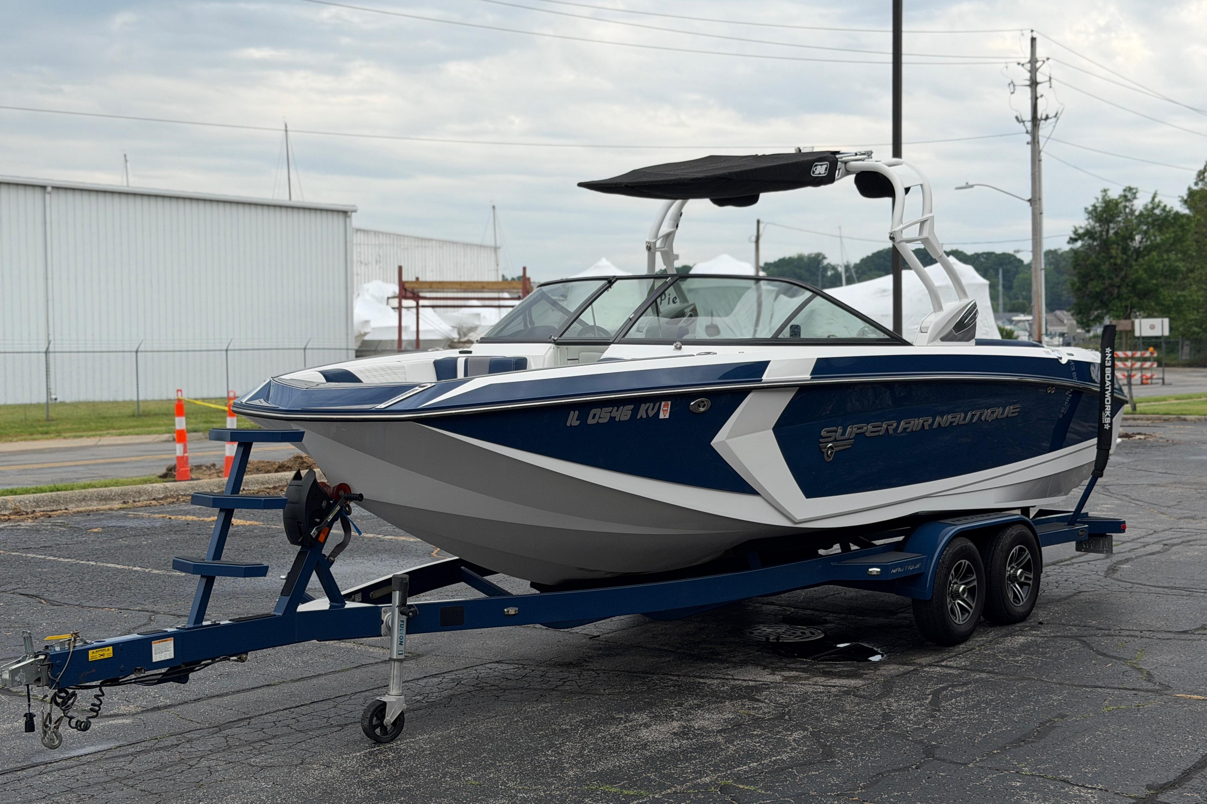 2016 Naitique G25 boat on trailer in parking lot, overcast sky.