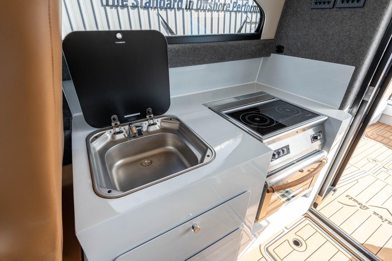 Compact kitchen in 2025 Makaira Gen 3 36 boat with sink and stove.