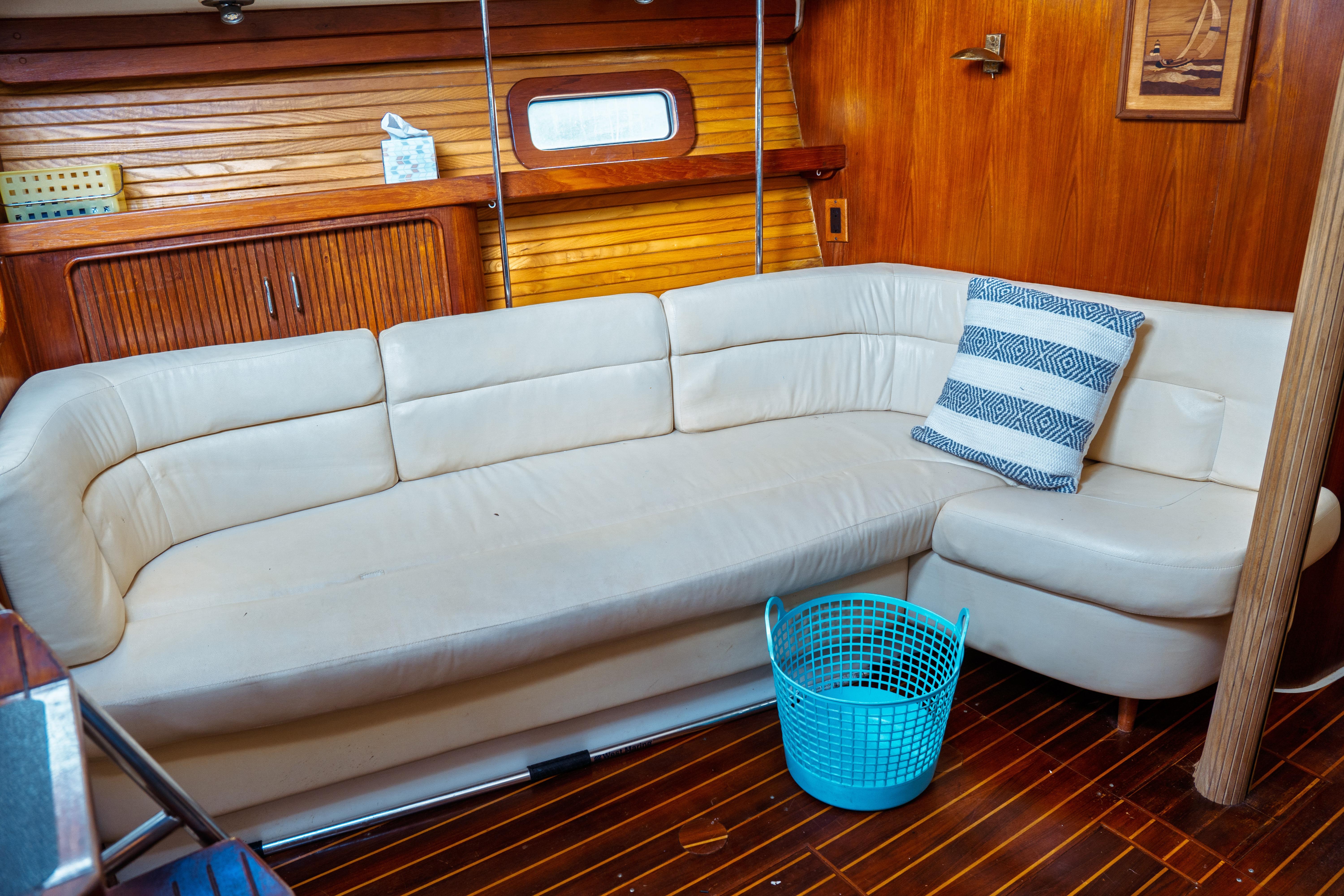 Interior of 1994 Catalina 38 CC yacht with white sofa and blue basket.