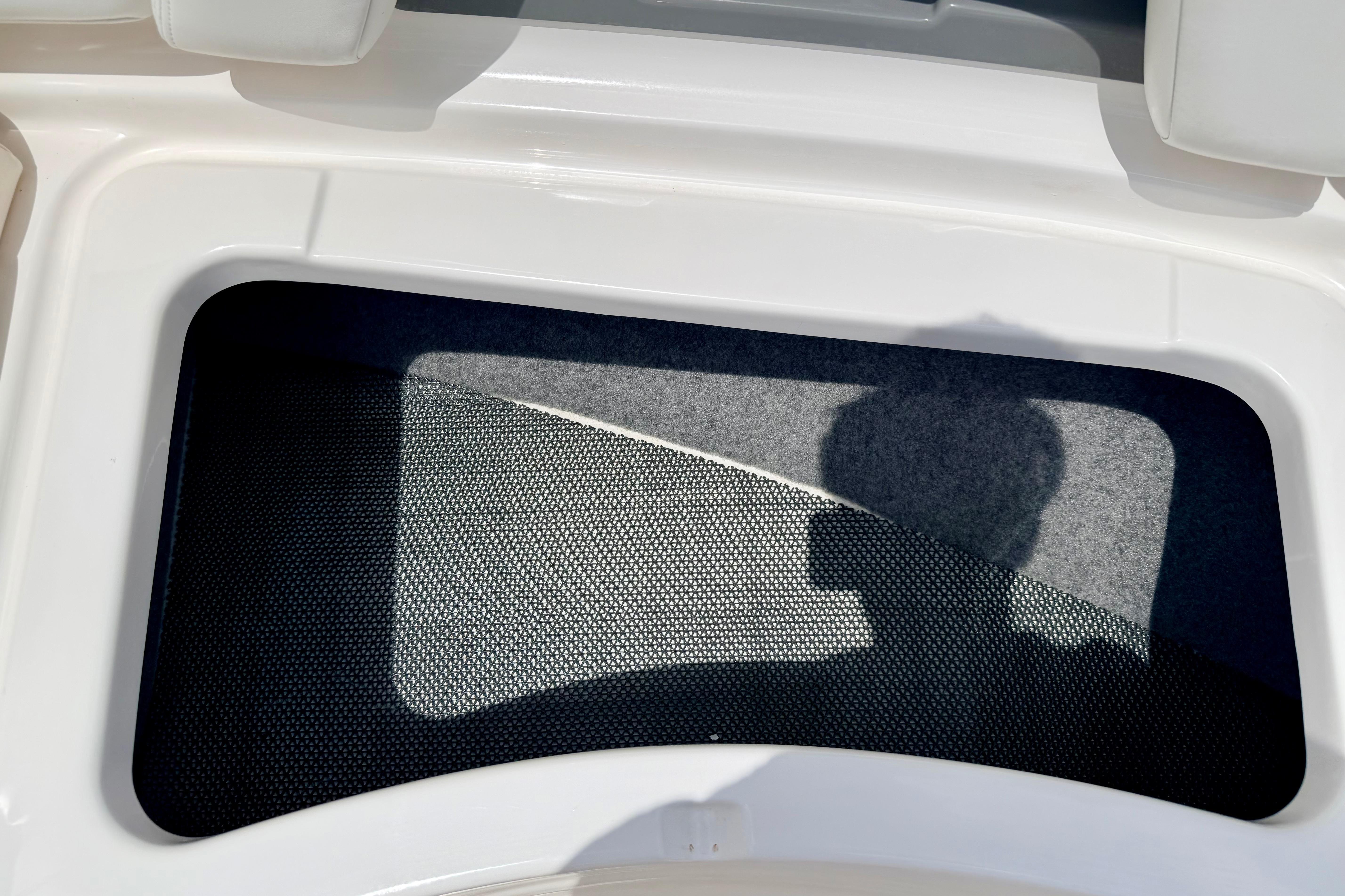 Storage compartment on a 2015 Chaparral Sunesta 264 boat, featuring a mesh cover.