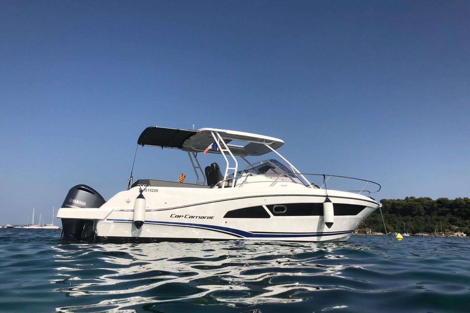 2020 Jeanneau Cap Camarat 9.0 WA boat on calm water under clear blue sky.