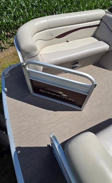 The image shows the deck of a 2018 Bennington 18SL boat with beige seating.