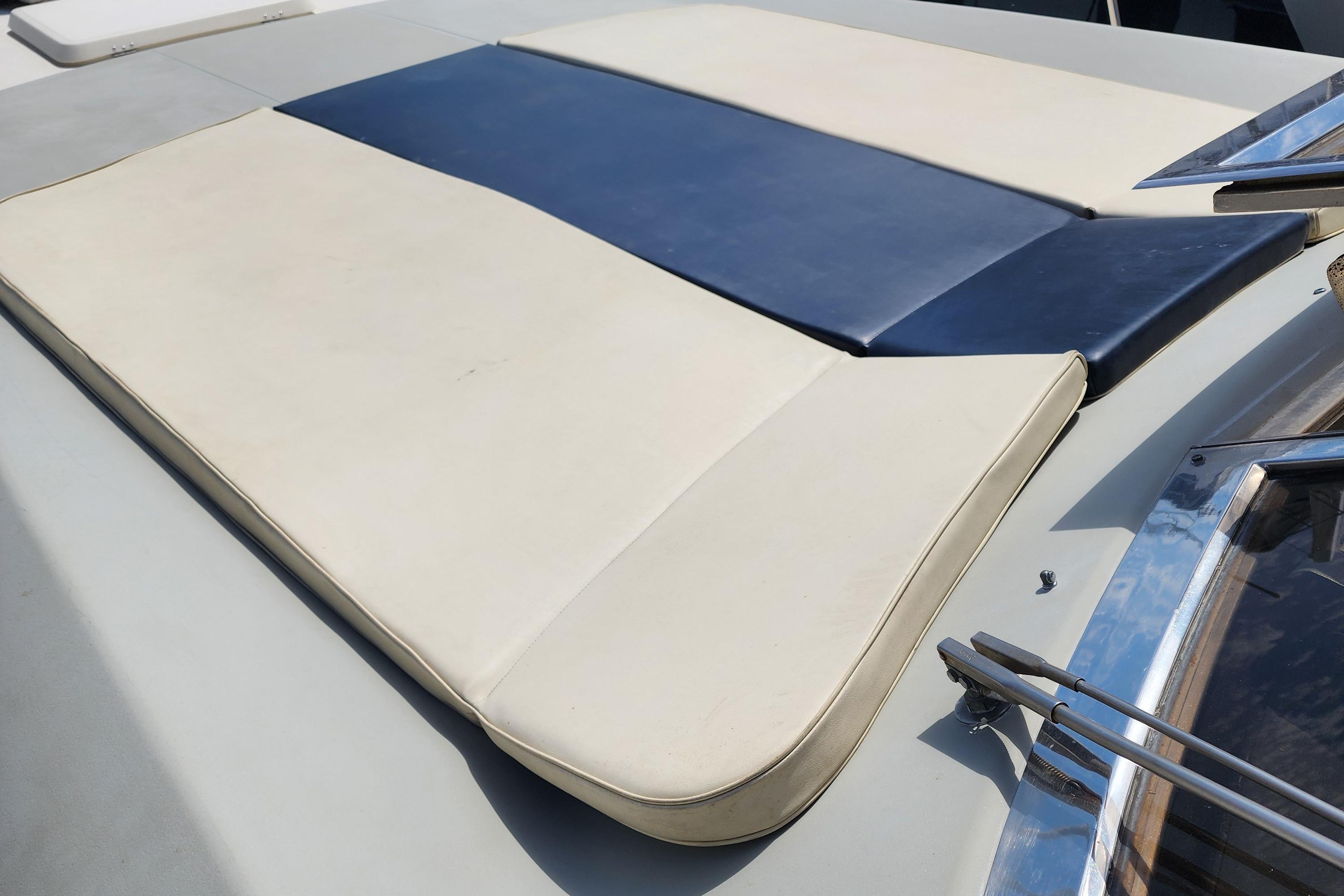 1987 Riva SuperAmerica boat with beige and blue cushioned seating on deck.