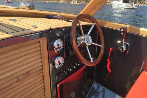 2026 Black Pepper Tender 24 boat interior with wooden steering wheel and control panel.