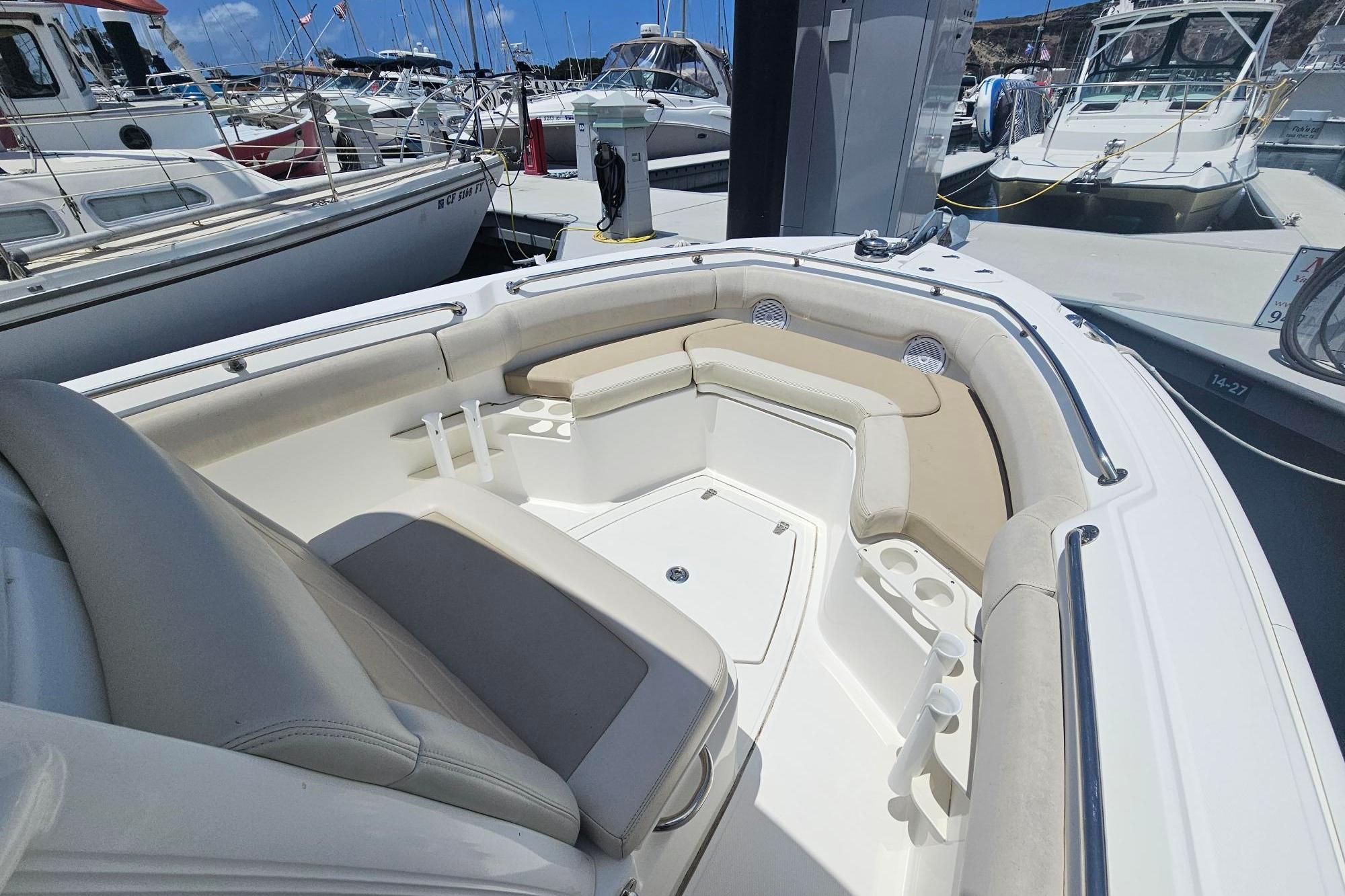 2017 Boston Whaler 230 Outrage boat interior with cushioned seating and cup holders at a marina.