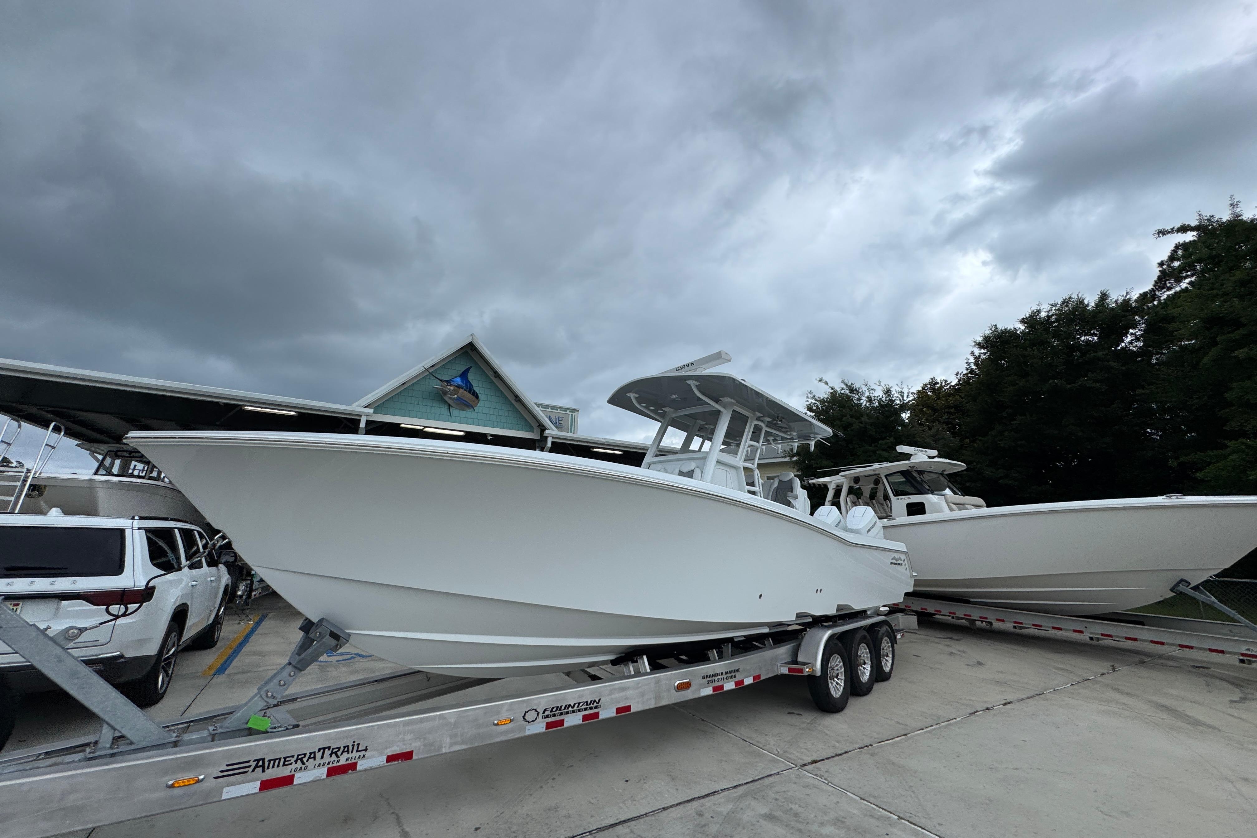 2026 Invincible 33 Open Fisherman boat on trailer under cloudy sky.