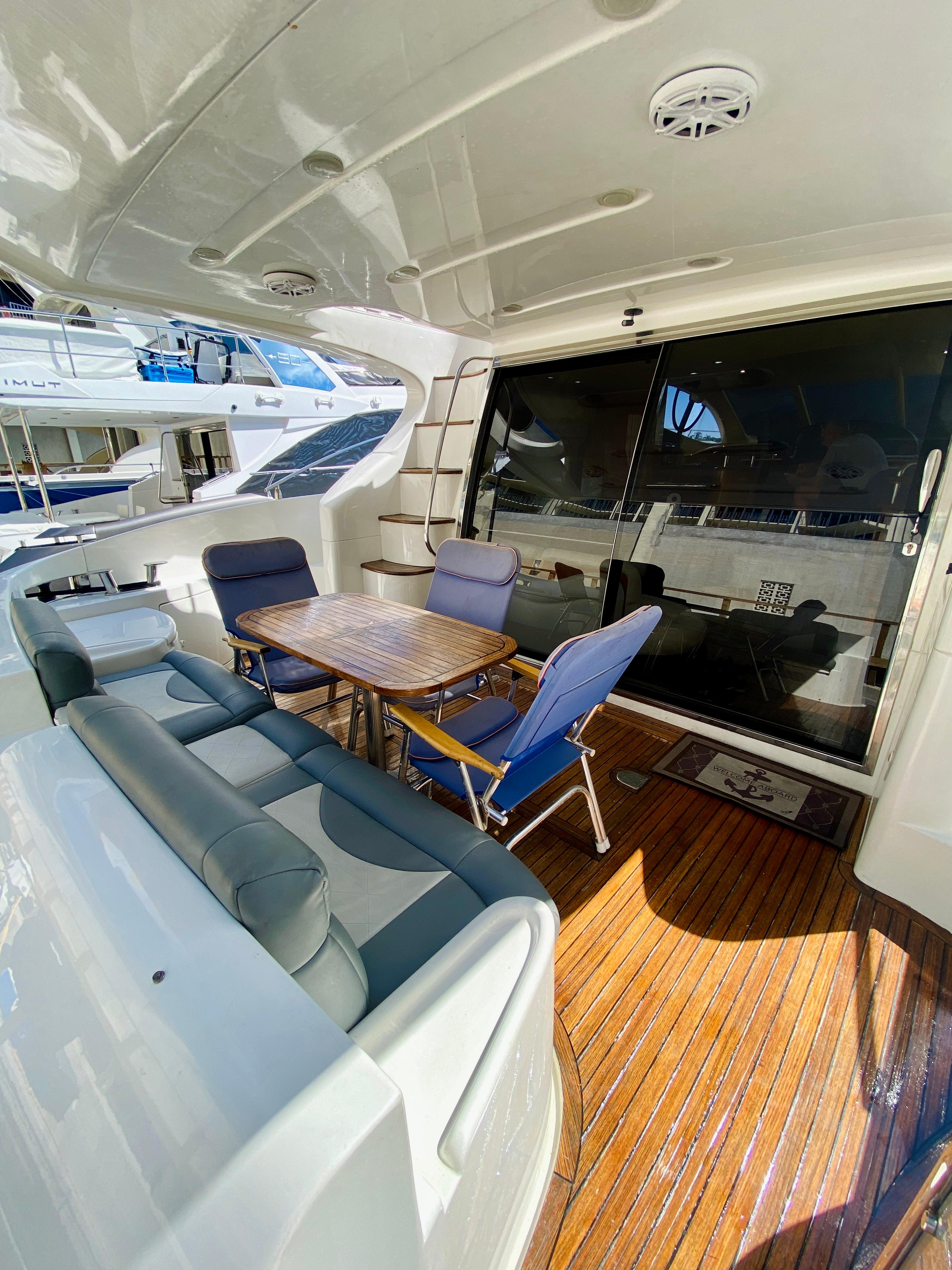 Azimut 55 yacht 2002 model, featuring a spacious outdoor seating area with wooden flooring.