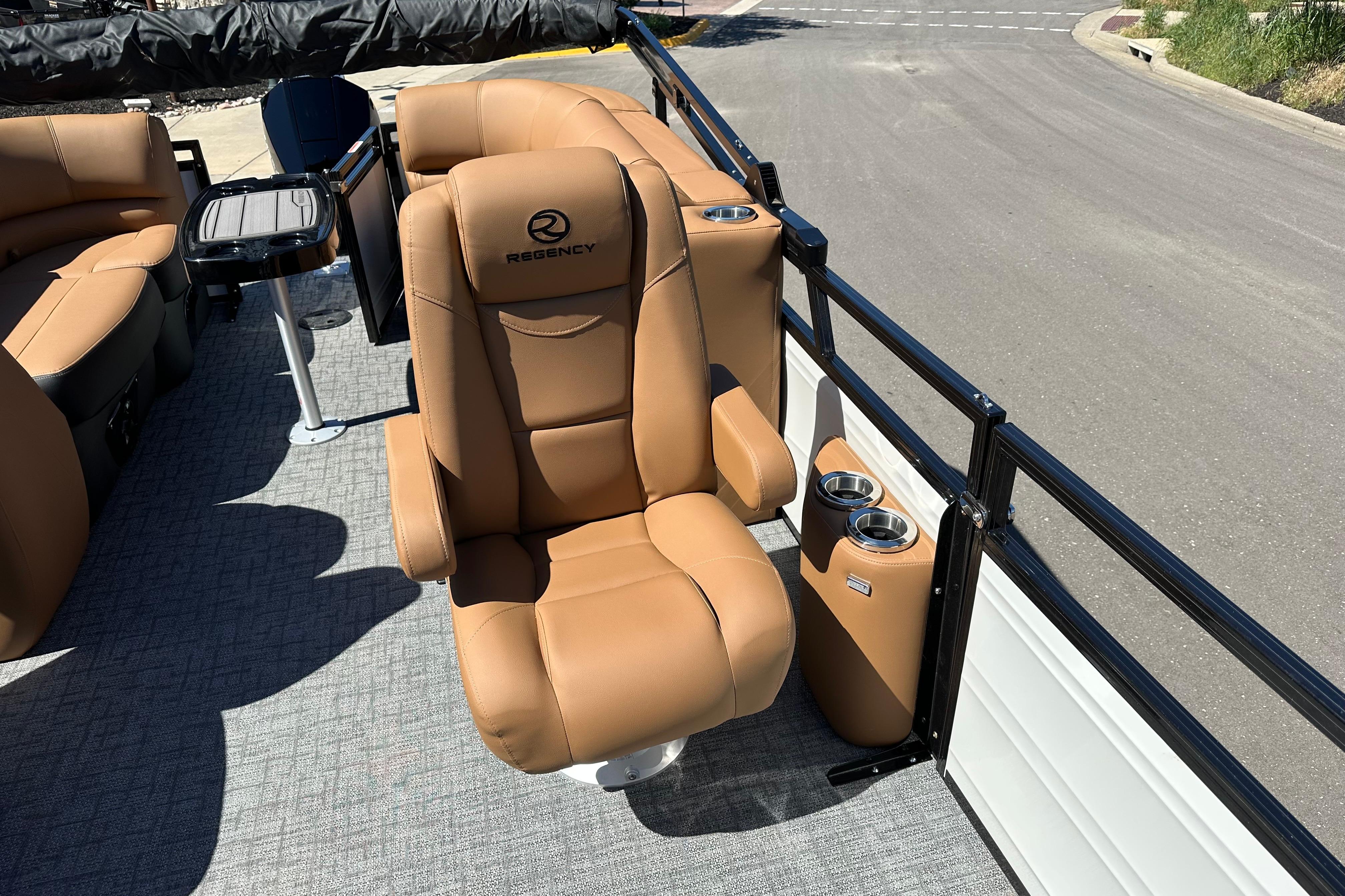 Luxurious seating on 2026 Regency 230 DL boat with tan upholstery and cup holders.