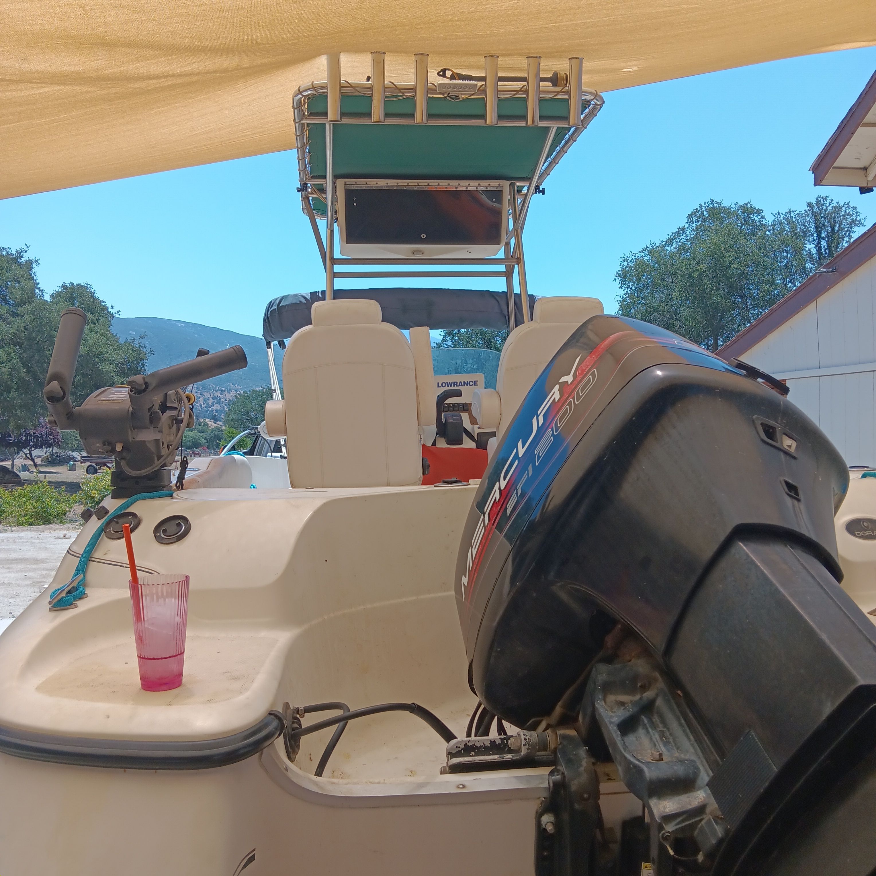 A 1998 Doral Ibiza 22 CC with an outboard motor and cockpit under a sunshade.
