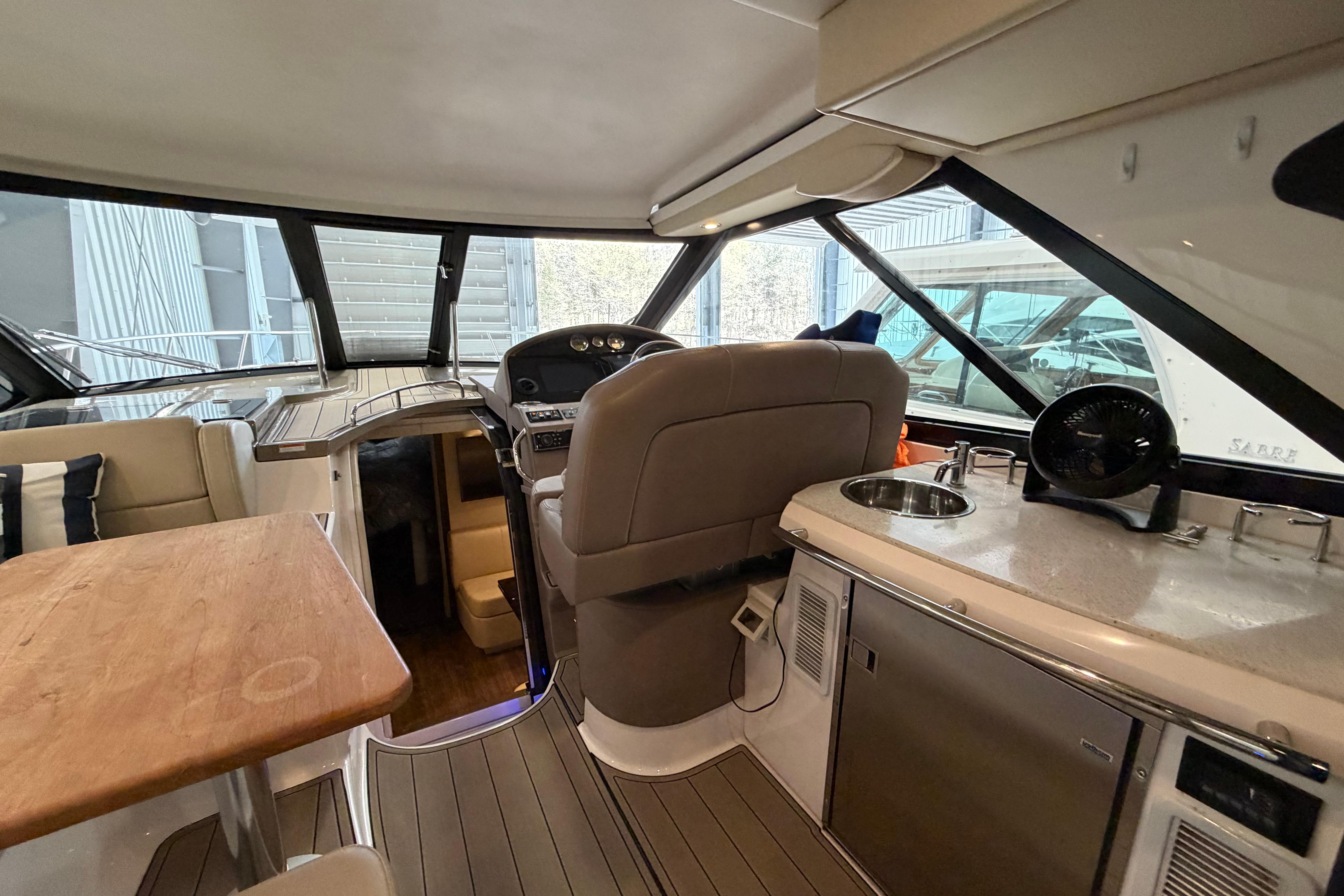 Interior of 2018 Regal 42 Sport Coupe yacht with helm, seating, and kitchenette.