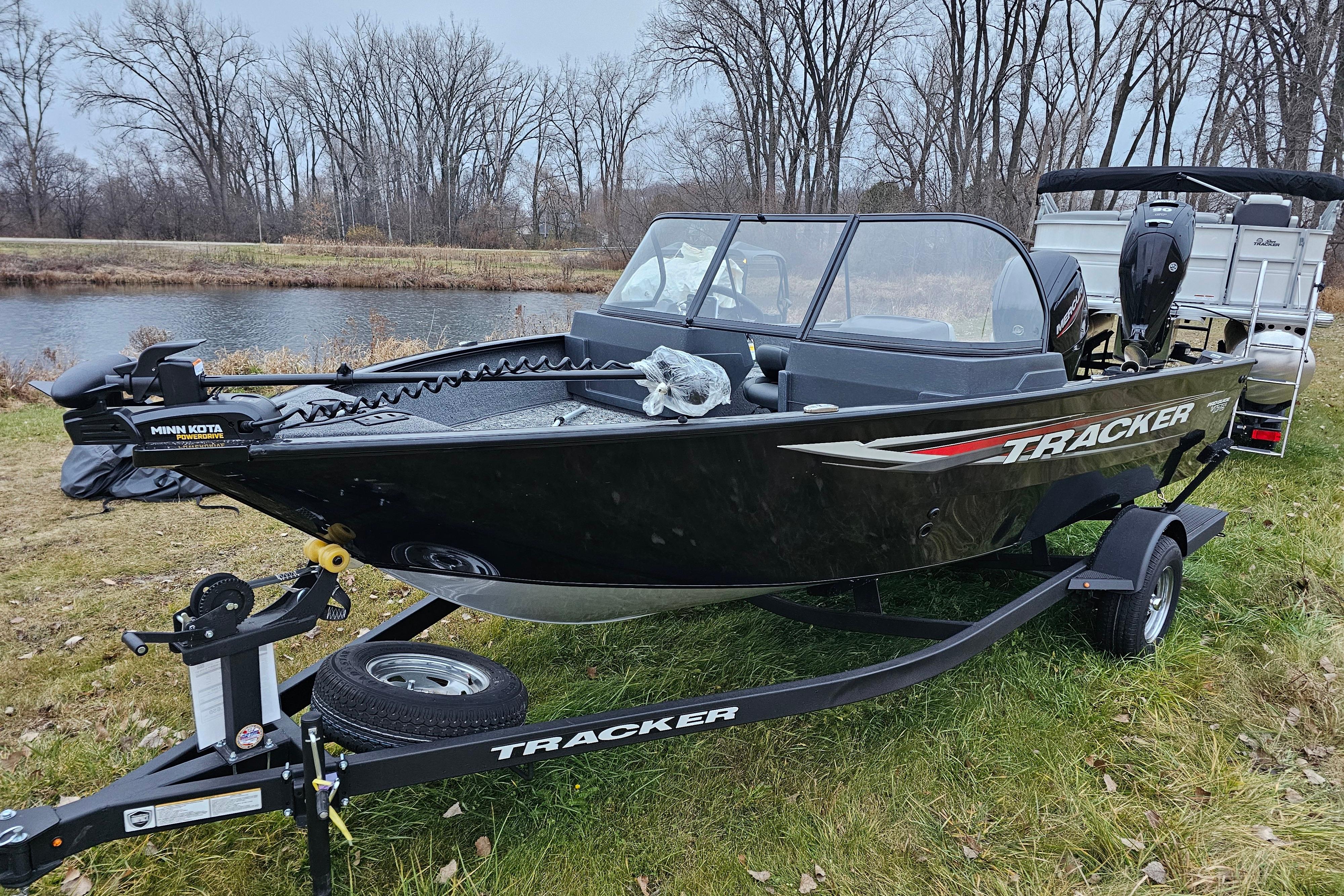 2026 Tracker Pro Guide V-175 WT boat on trailer by a lake.