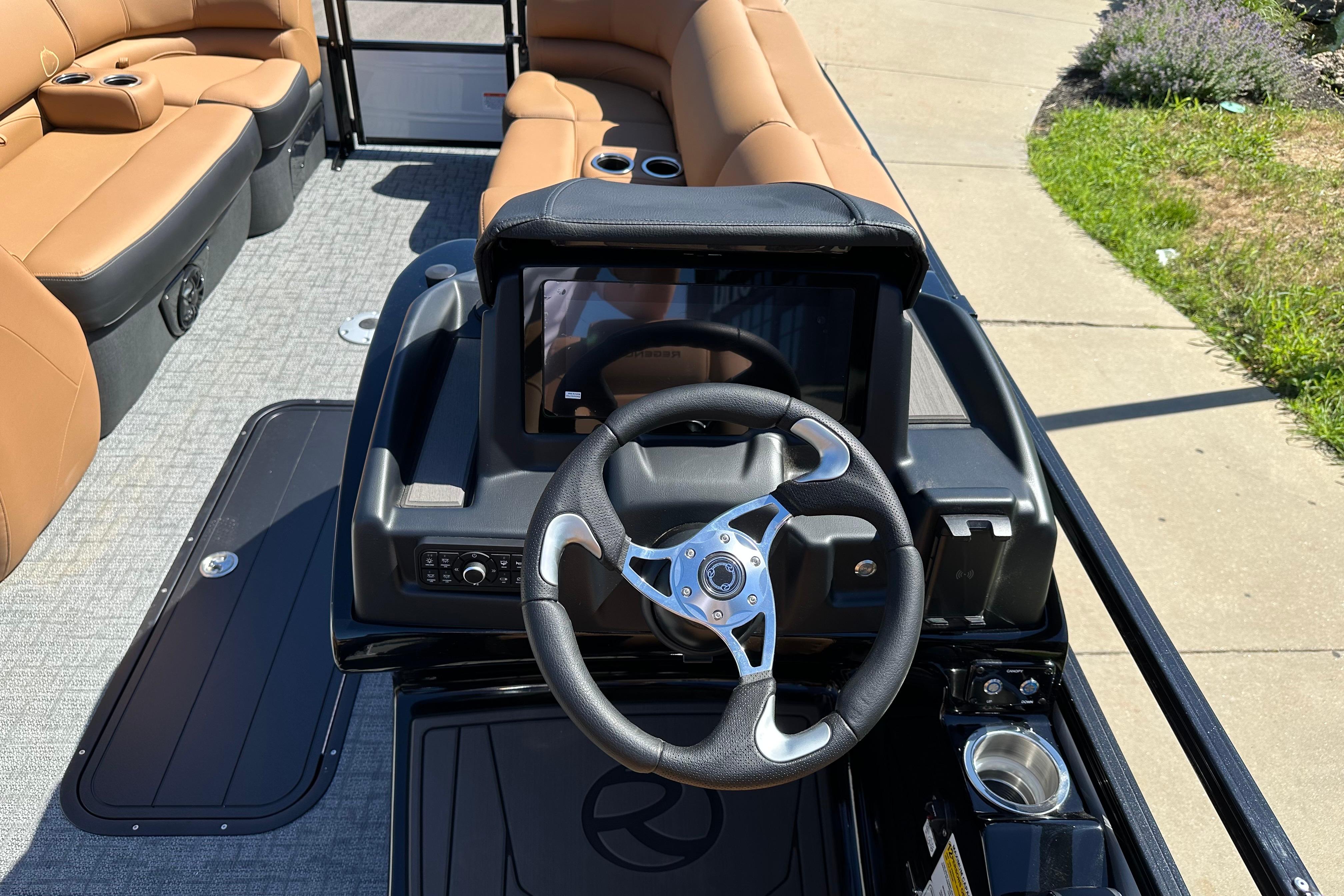 2026 Regency 230 DL boat interior with steering wheel and tan seating.