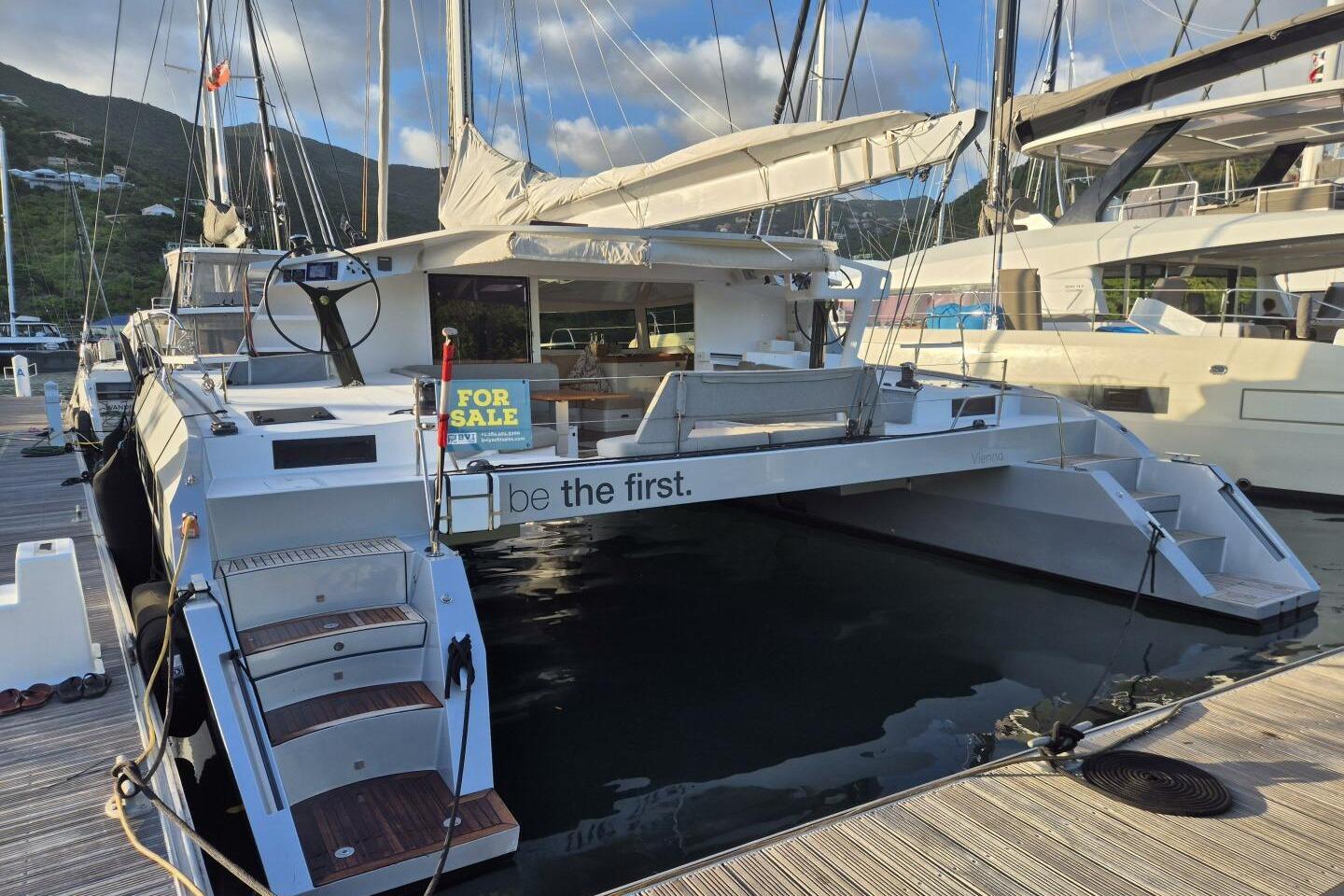 2016 Alibi 54 catamaran for sale, docked at marina, sunny day.