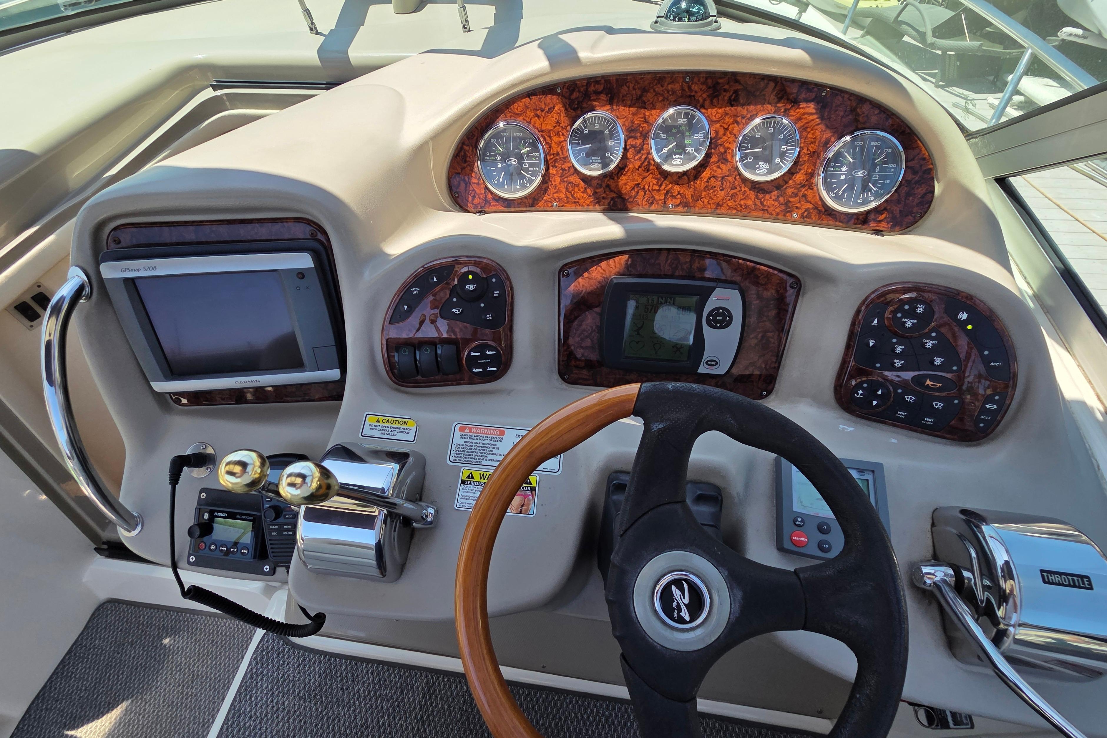 Cockpit of 2006 Sea Ray Sundancer 320 with steering wheel, gauges, and navigation controls.