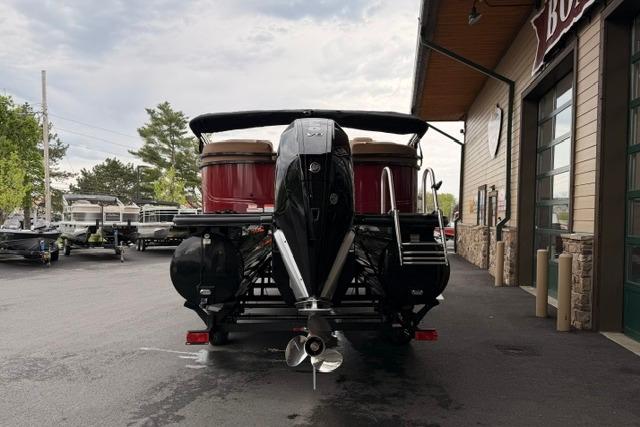 2026 Regency 230 DL boat with powerful outboard motor, parked outside a dealership.