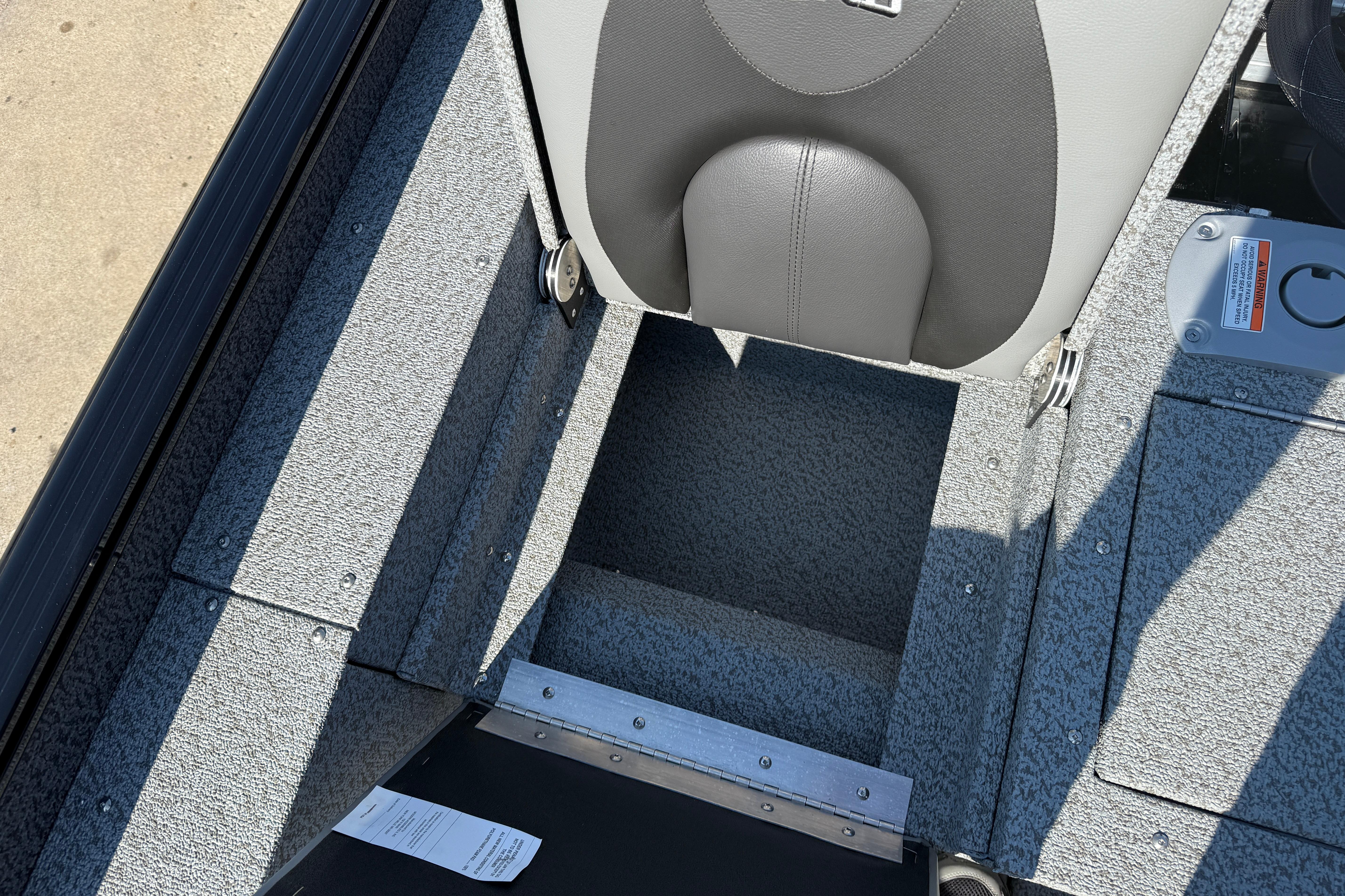 2026 Lund 1675 Adventure SS boat interior with storage compartment and seat detail.