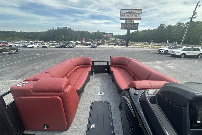 2026 Regency 230 DL pontoon boat with red seating, parked in a dealership lot.