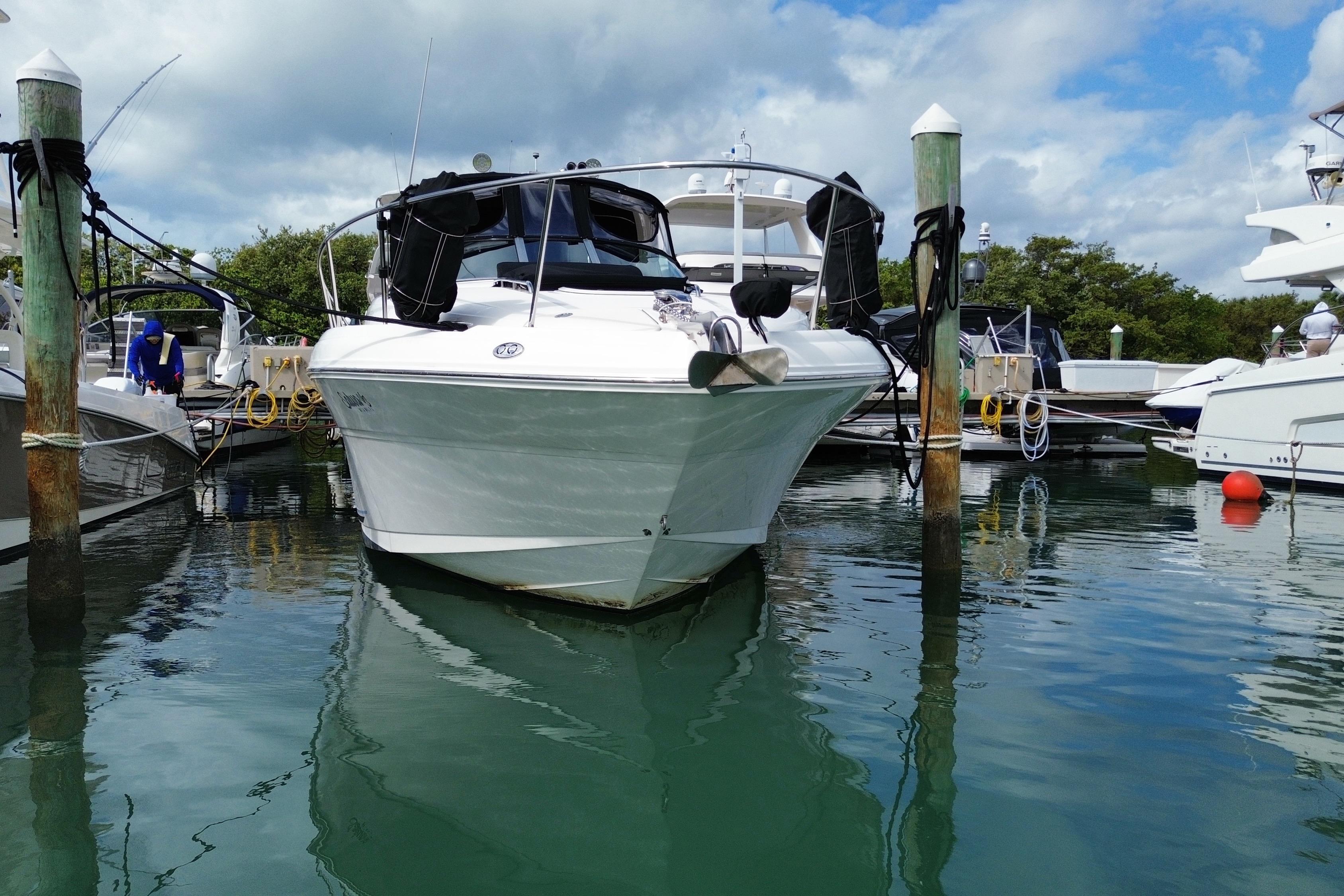 2004 Sea Ray 340 Sundancer yacht docked at marina under cloudy sky.
