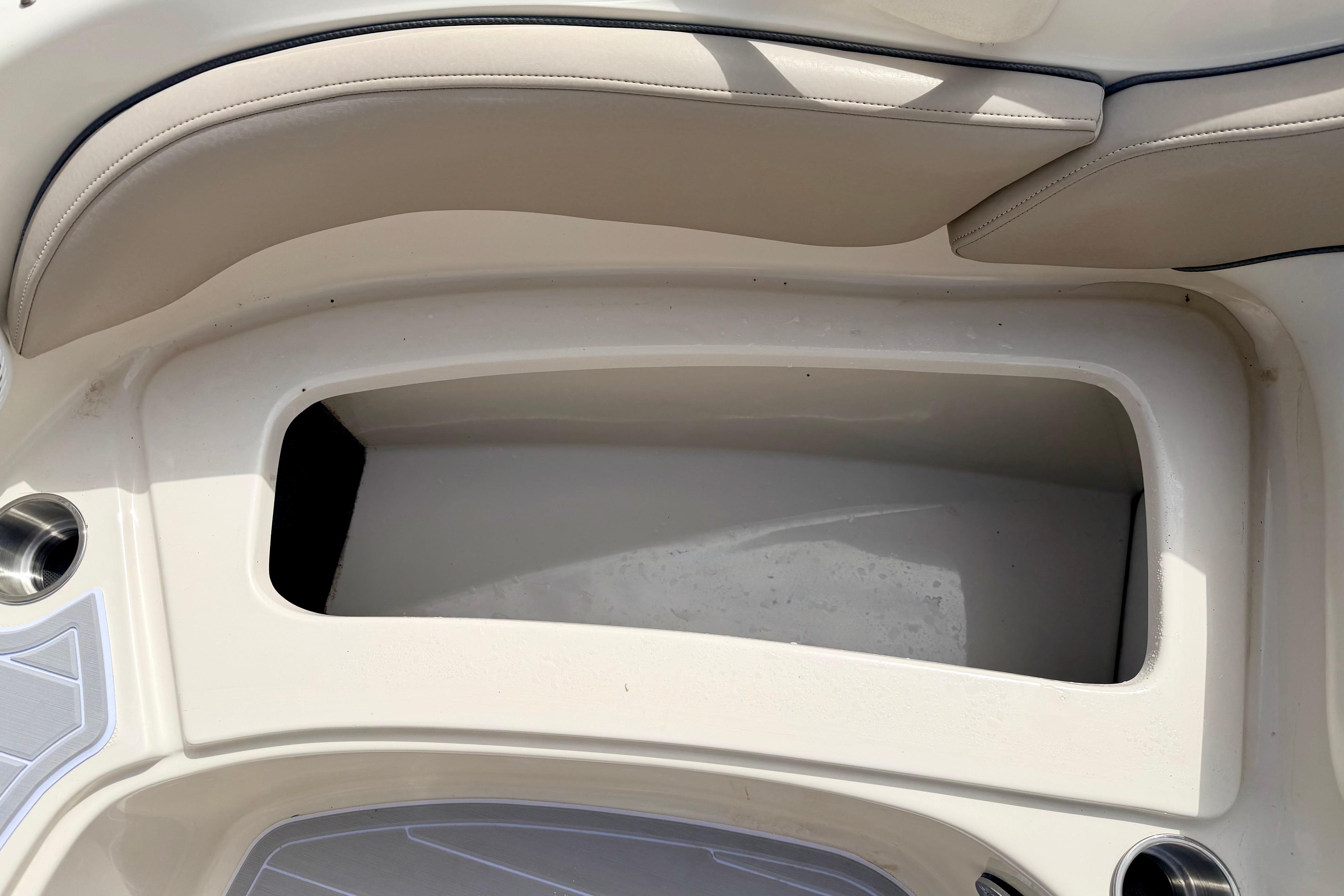Storage compartment on a 2003 Sea Ray 200 Sundeck boat, featuring beige seating.