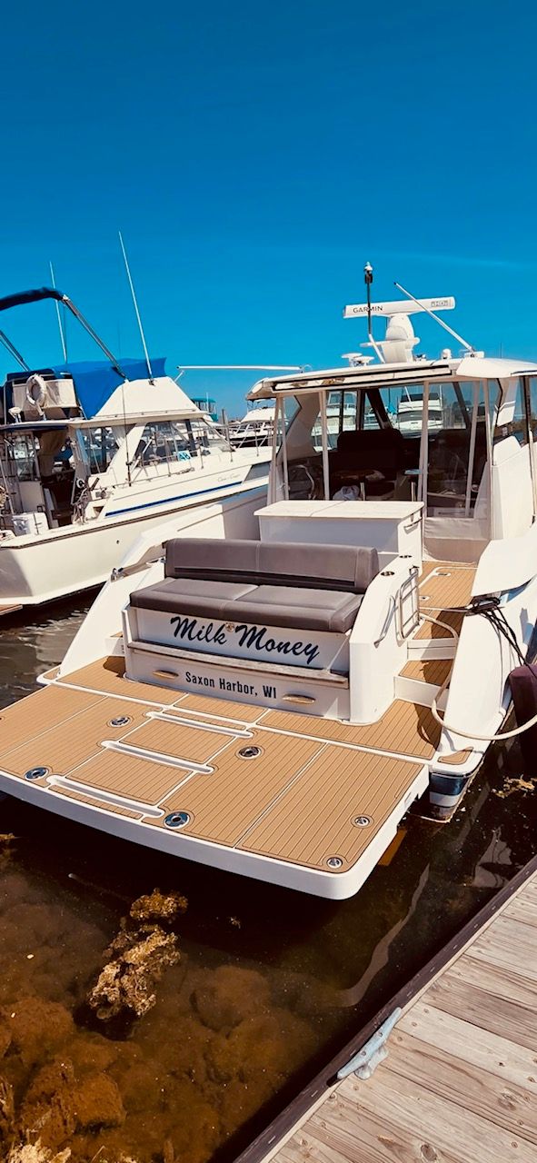 A 2017 Tiara Yachts Q44 docked, featuring a spacious aft deck.