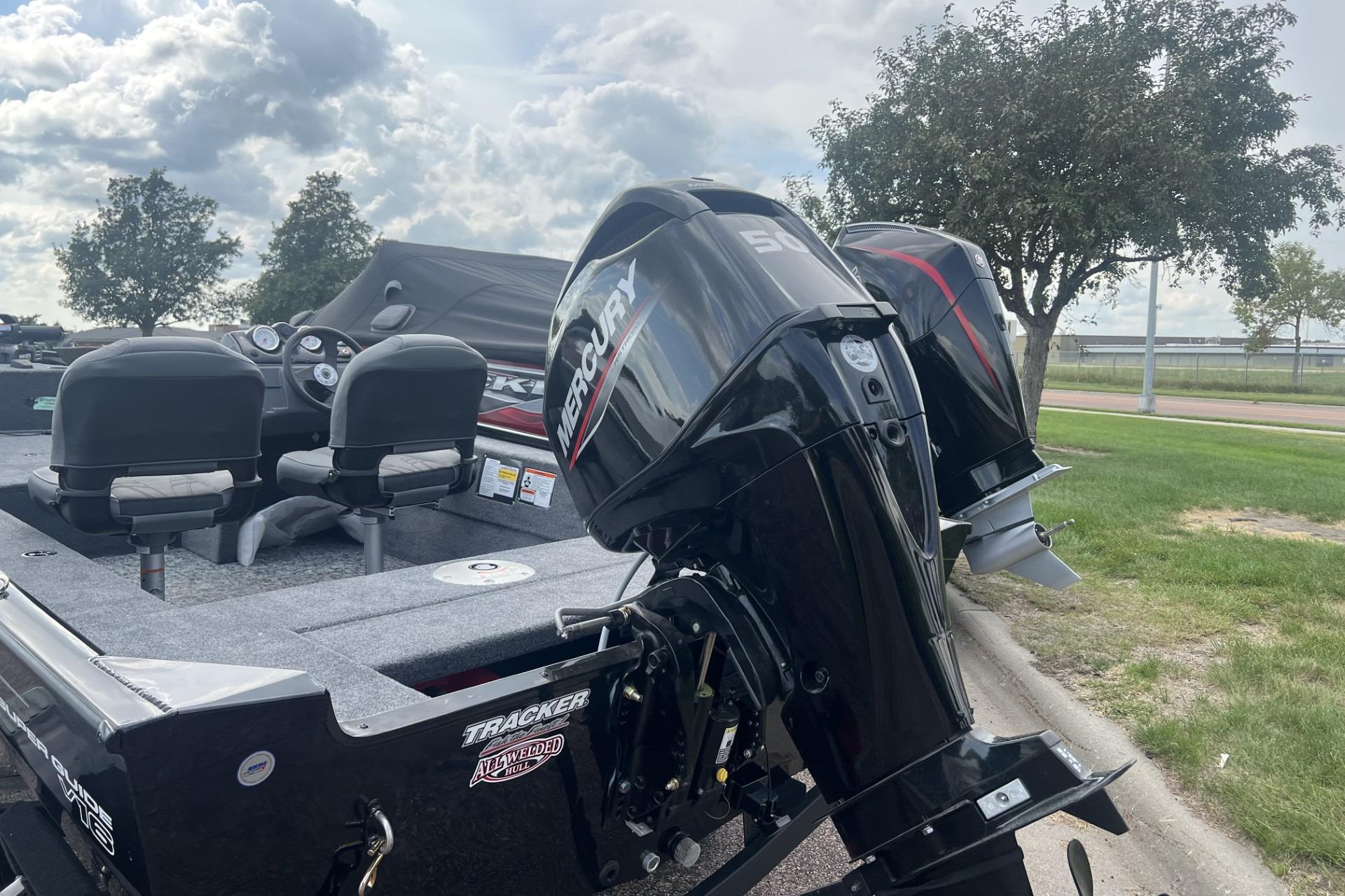 2026 Tracker Super Guide V-16 SC boat with Mercury outboard motor, parked outdoors.