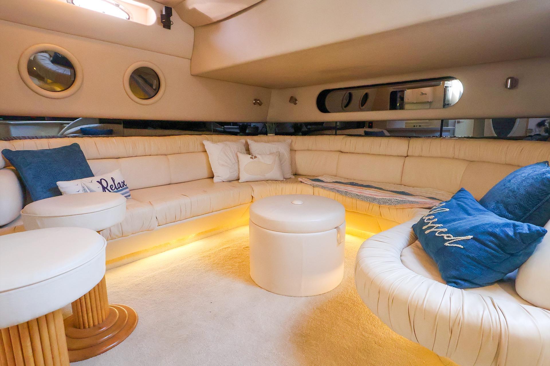 Luxurious interior of a 1998 Sea Ray 500 Sundancer yacht with plush seating and ambient lighting.