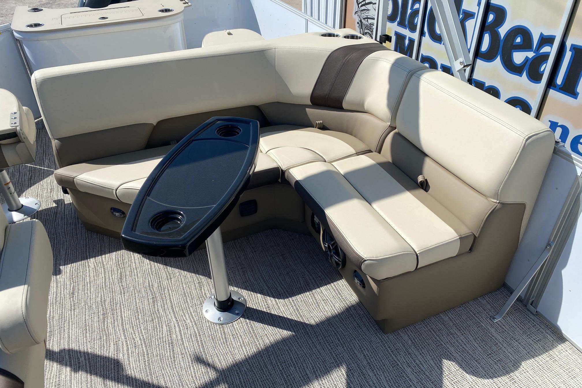 Luxurious seating area on 2026 SunCatcher Select 22RF pontoon boat with sleek table design.