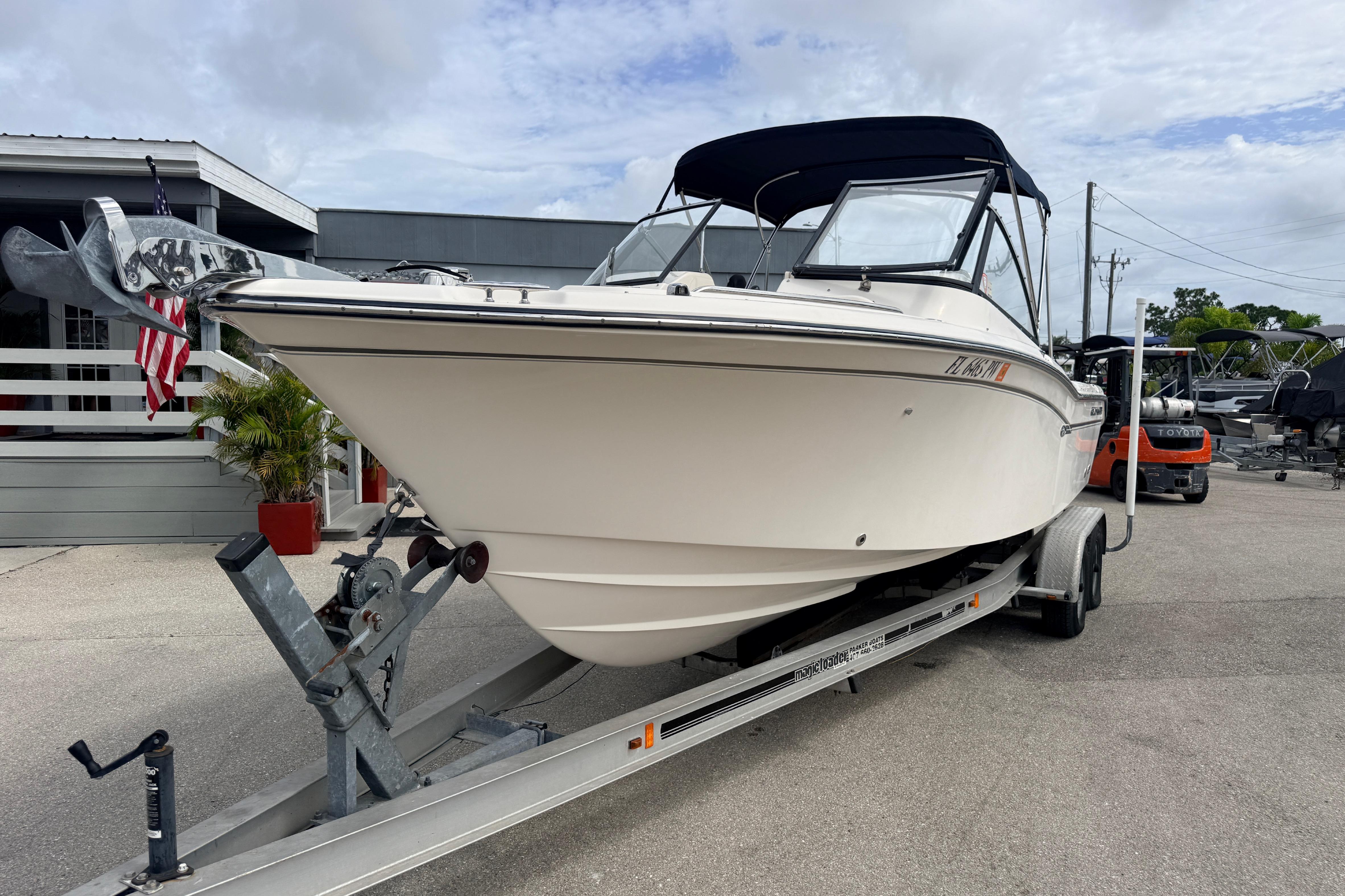 2015 Grady-White Freedom 255 boat on trailer, parked outdoors with American flag nearby.