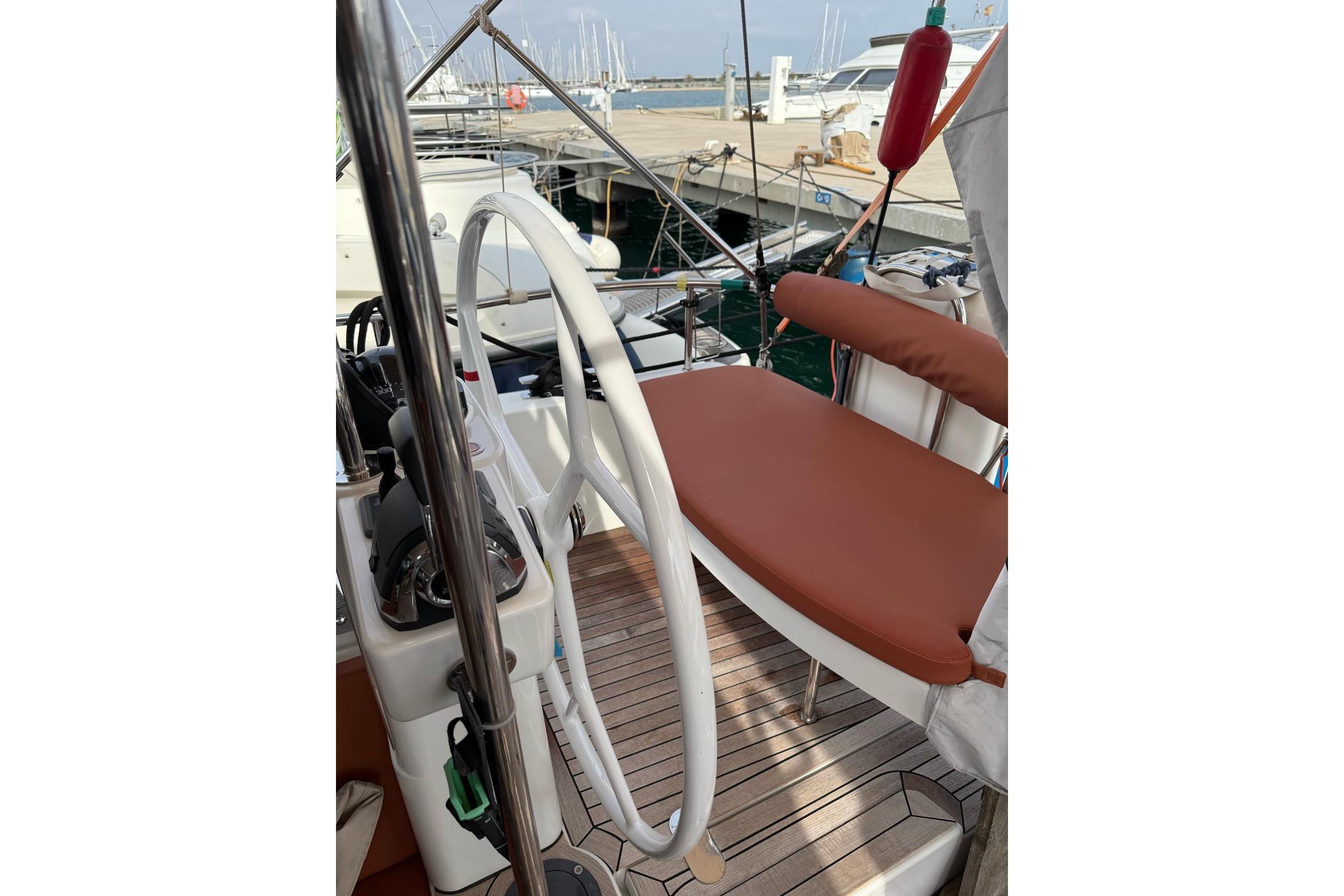 Cockpit of 2020 Moody 45 DS yacht with teak flooring and white steering wheel.