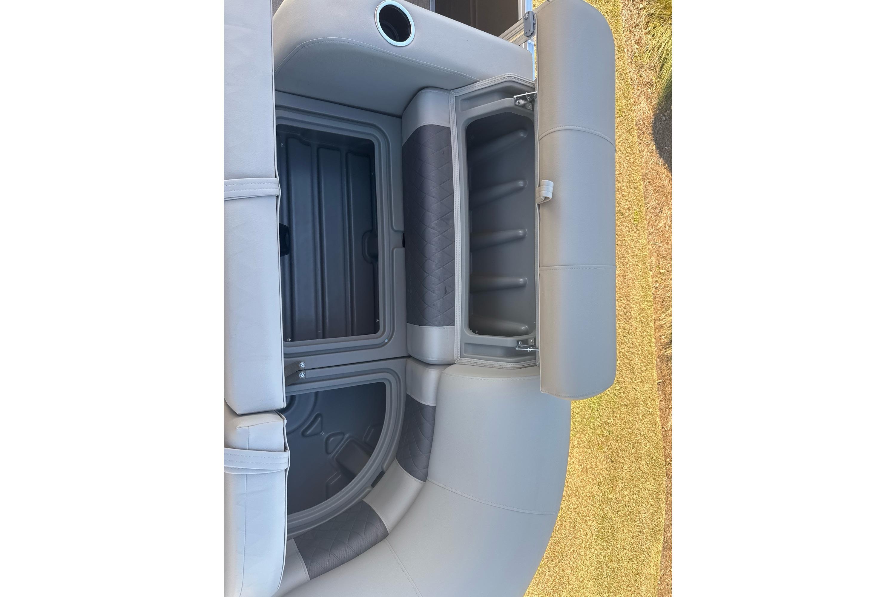 2025 Sun Tracker SportFish 22 DLX boat seat storage compartment, open and empty.