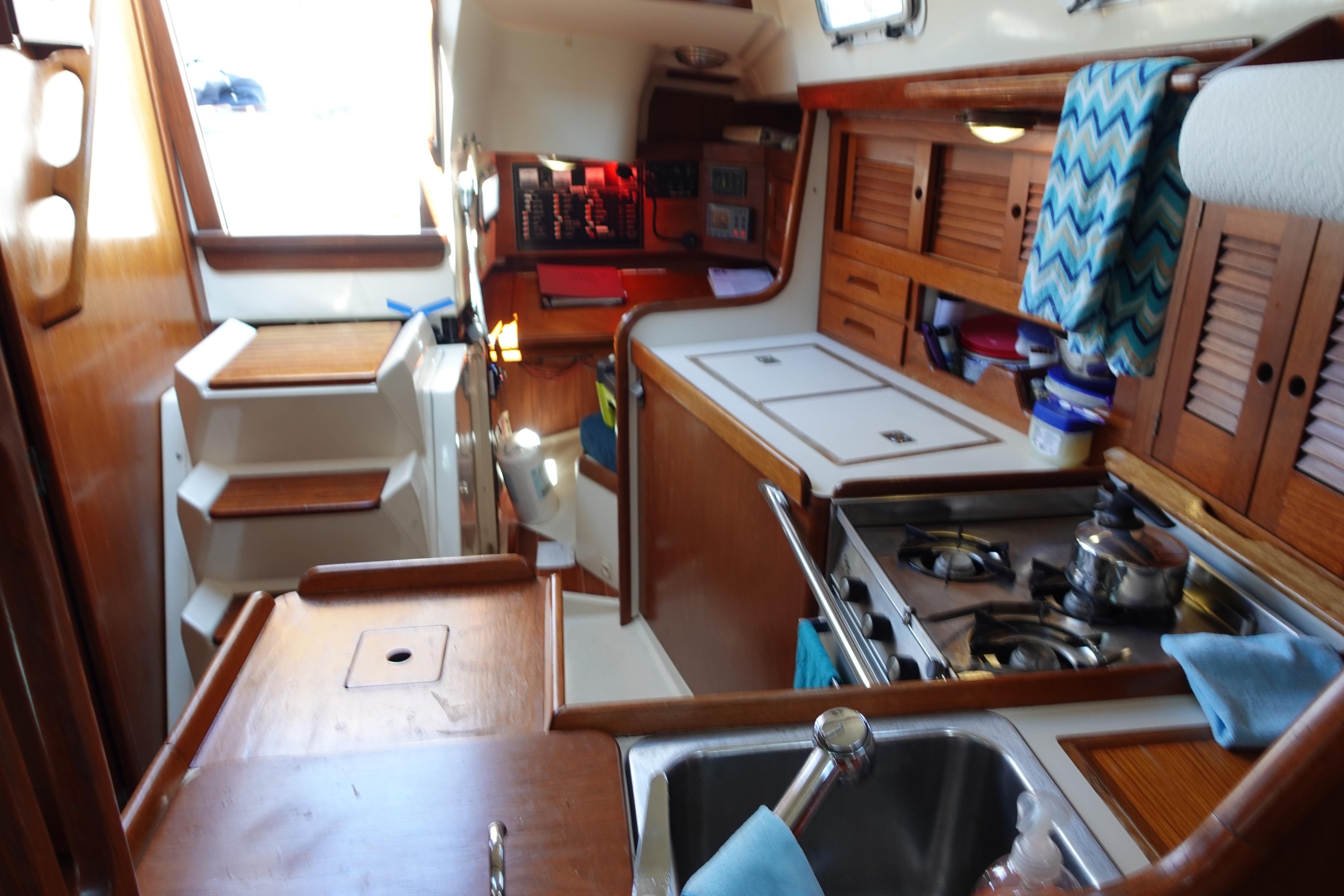 Interior of 1987 Tartan Marine 40 sailboat with kitchen and wooden cabinetry.