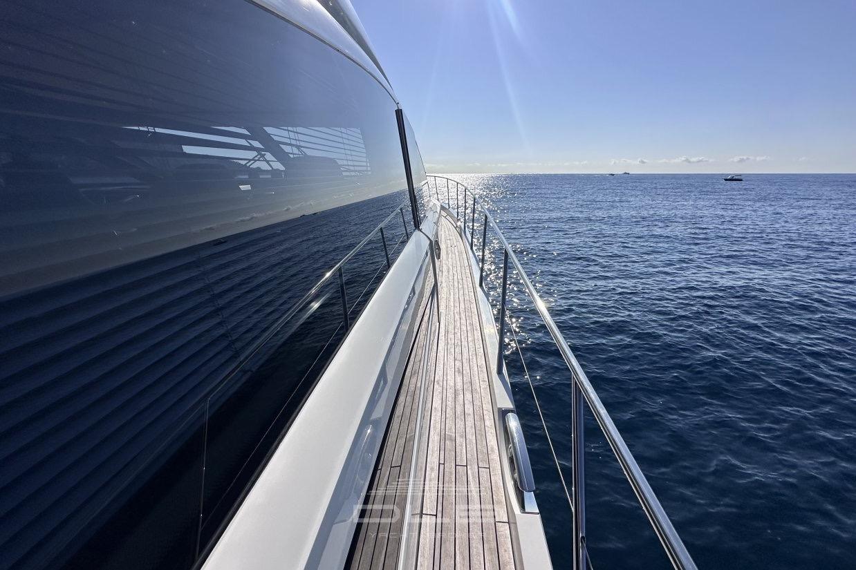Side view of a 2006 Princess V70 yacht cruising on a sunny ocean.