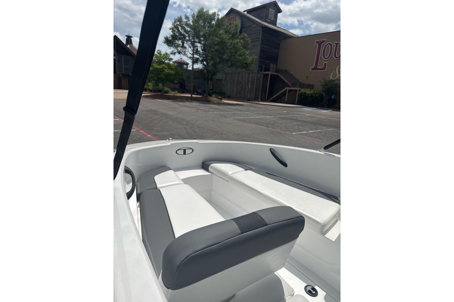 2026 Tahoe T16 boat interior with white and gray seating, parked outdoors.
