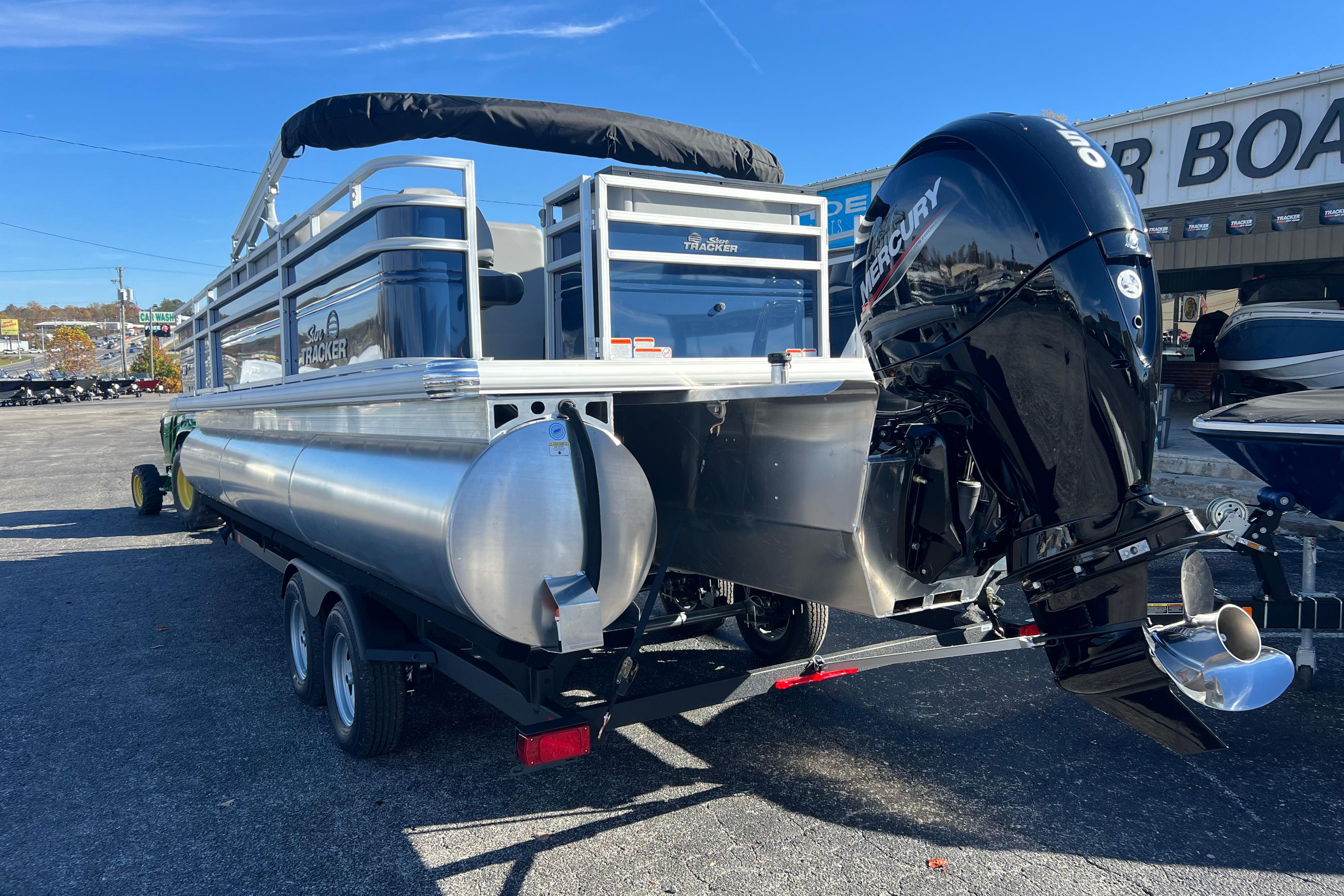 2026 Sun Tracker Sportfish 24 XP3 pontoon boat with Mercury outboard motor on trailer.