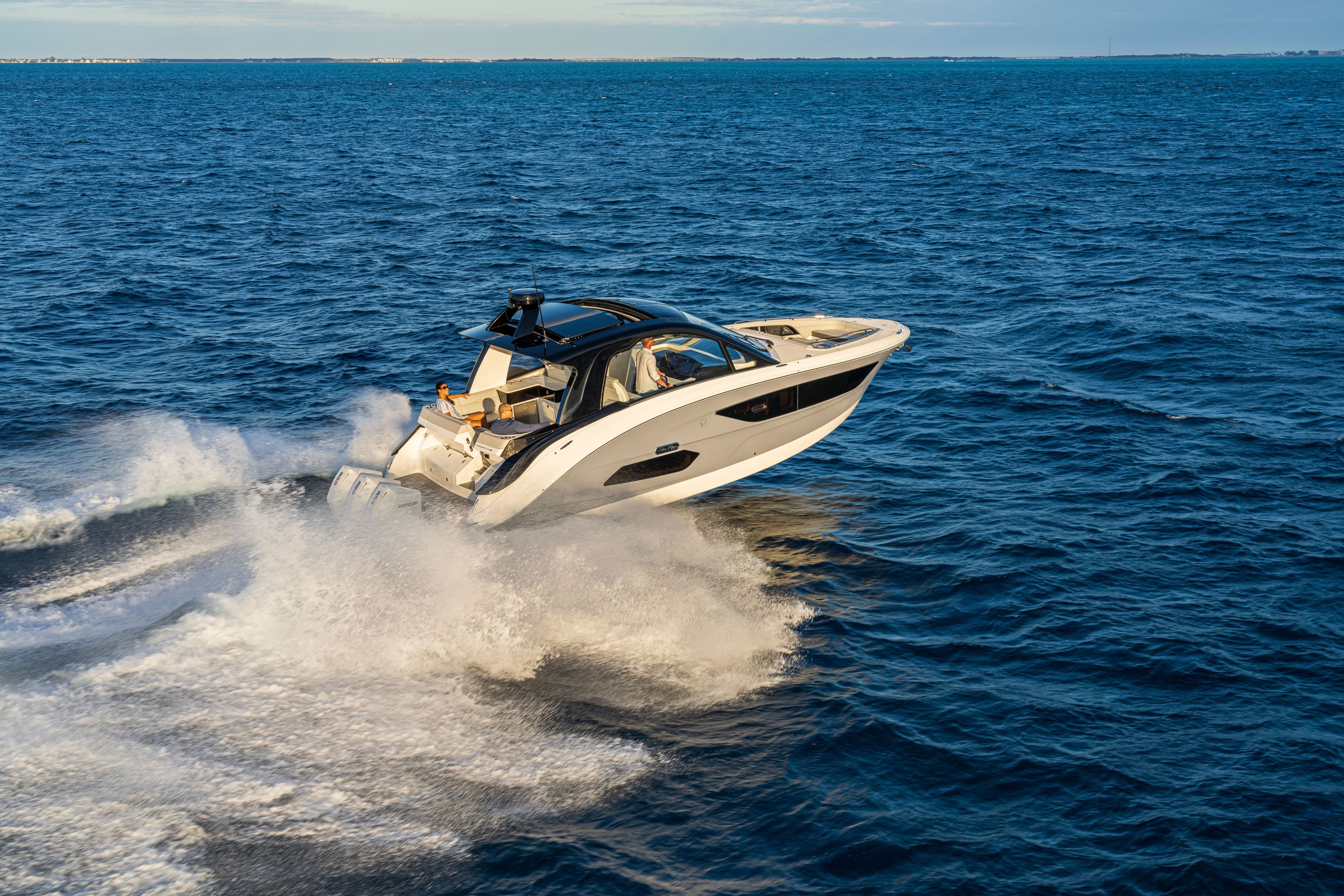 A 2026 Sea Ray Sundancer 370 Outboard speeding across the open sea.