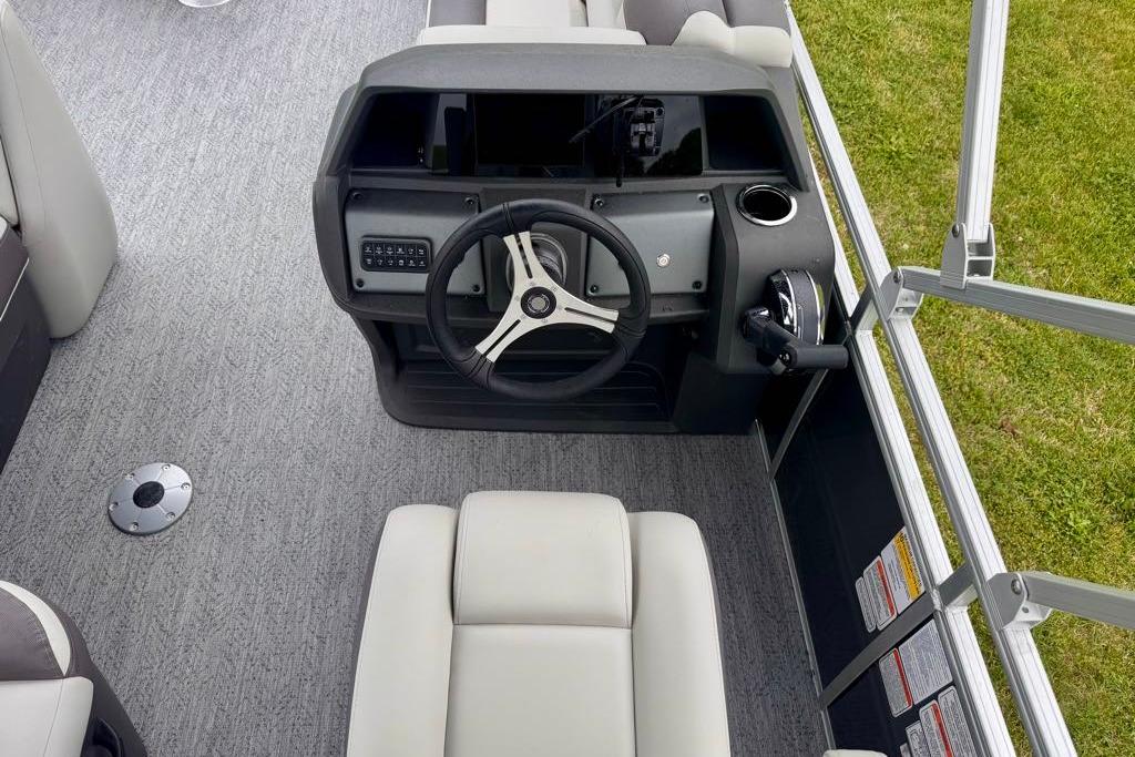 2026 Sun Tracker Fishin' Barge 20 DLX helm with steering wheel and control panel.