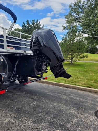 2024 Ranger Reata 223F boat with powerful outboard motor, parked on a scenic road.