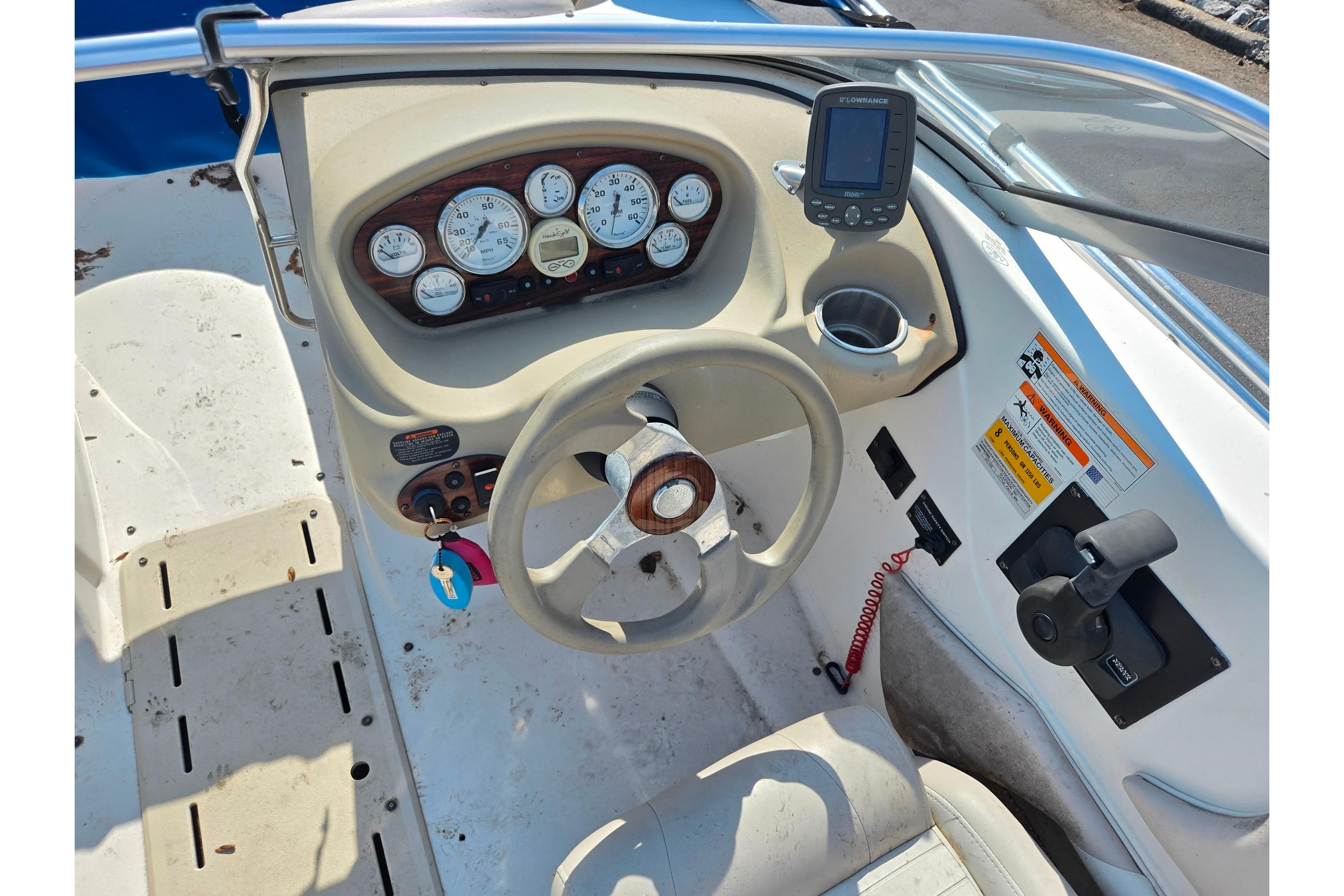 2007 Glastron GT 185 boat dashboard with steering wheel, gauges, and control panel.